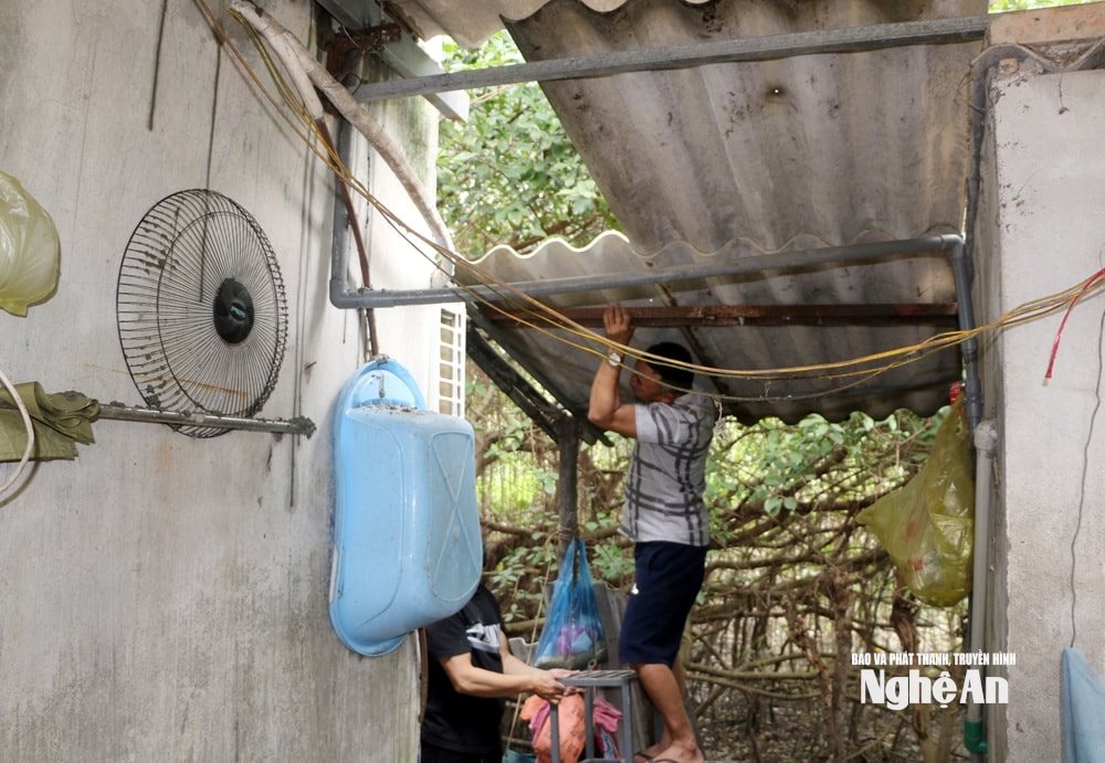 Anak lelaki Encik Tran Van Truong memasang semula bumbung rumah sementaranya selepas ribut. Foto oleh Nguyen Hai