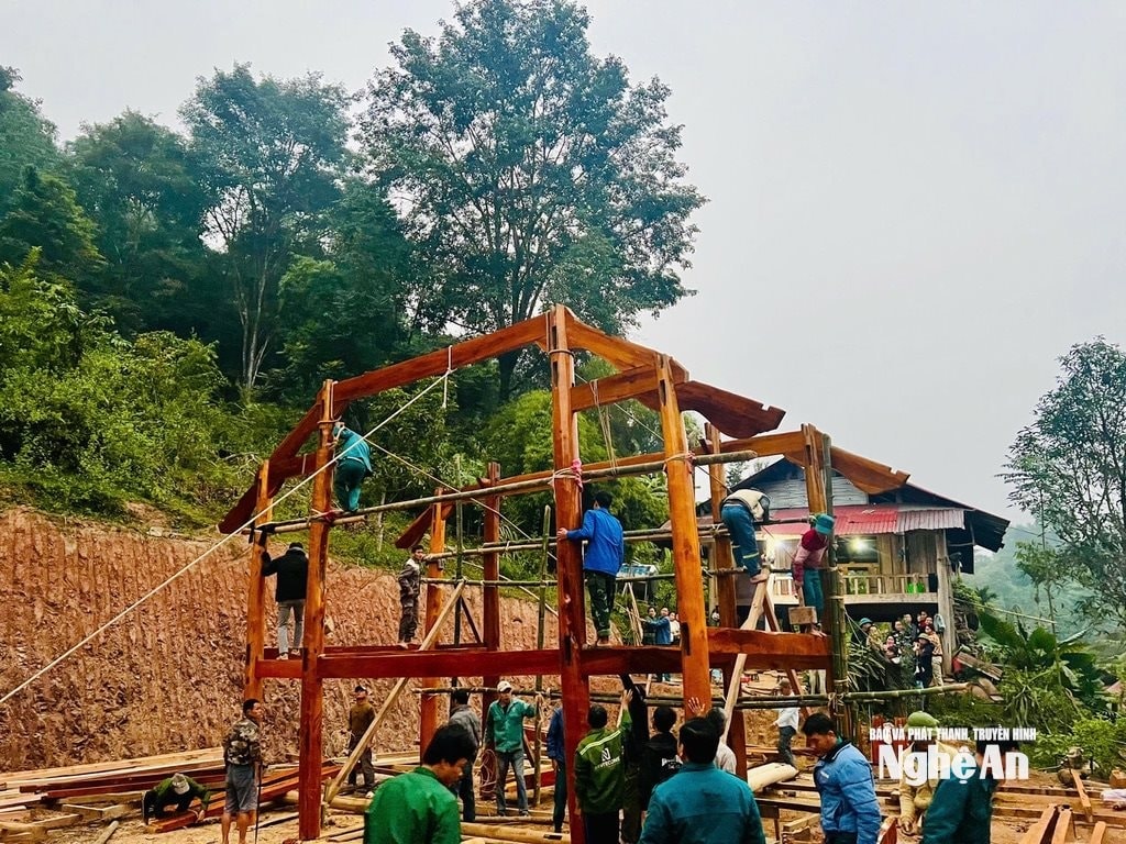 Các lực lượng giúp dân ở bản Na Hang, xã Nhôn Mai dựng nhà. Ảnh Văn Trường