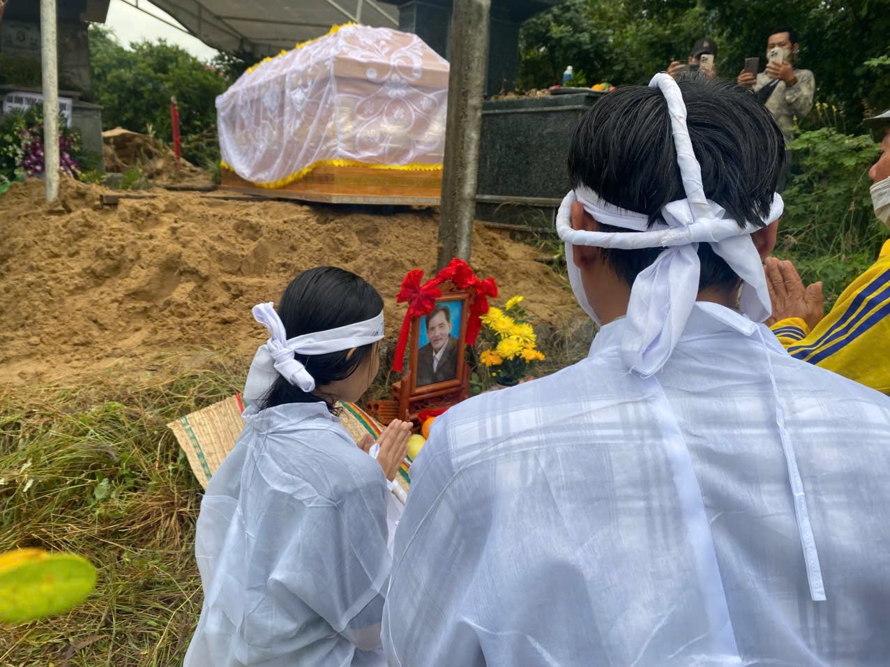 Hai con của Thương Tín trước lúc hạ huyệt.