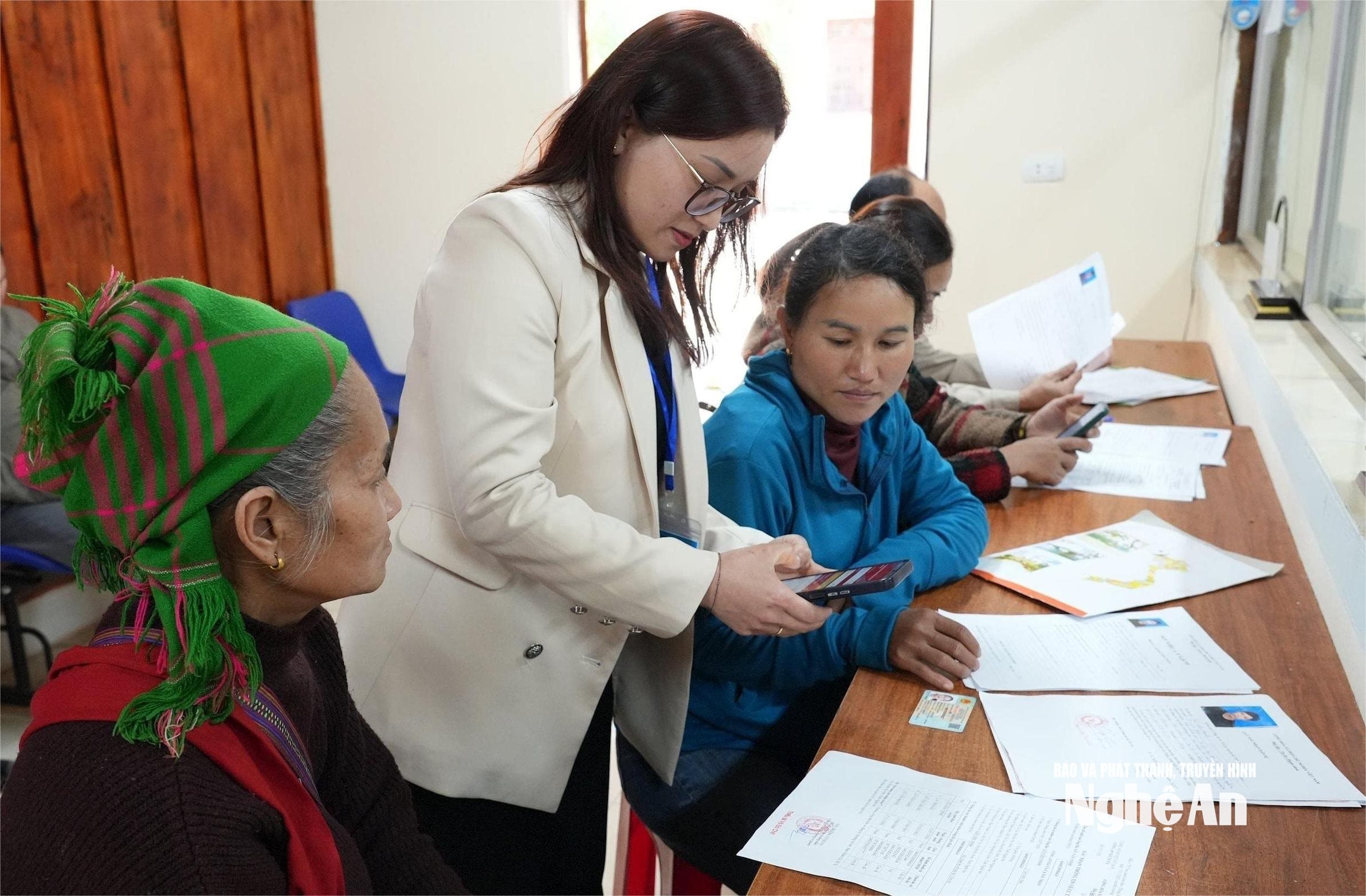 Cán bộ Tư pháp - Hộ tịch xã Tà Cạ (nay là xã Mường Xén) hướng dẫn người dân thực hiện giao dịch trên môi trường điện tử. Ảnh Tiến Đông