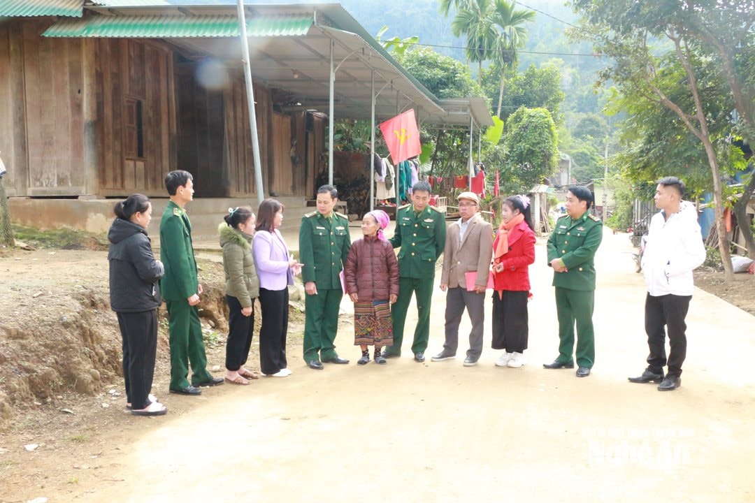 Bí thư Chi bộ bản Phồng Vi Thị Ánh (áo tím) trò chuyện với cán bộ Đồn biên phòng Tam Hợp, đảng viên và dân bản. Ảnh GH