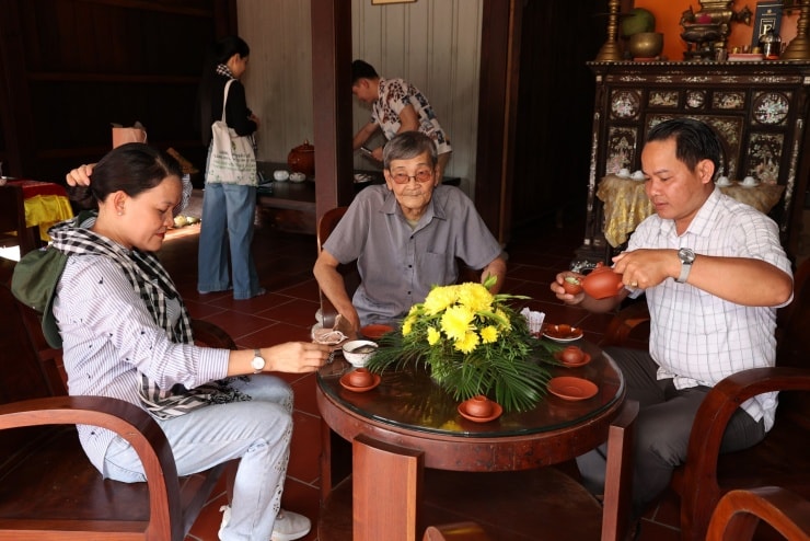 Chủ nhà mời trà tiếp khách đến thăm.
