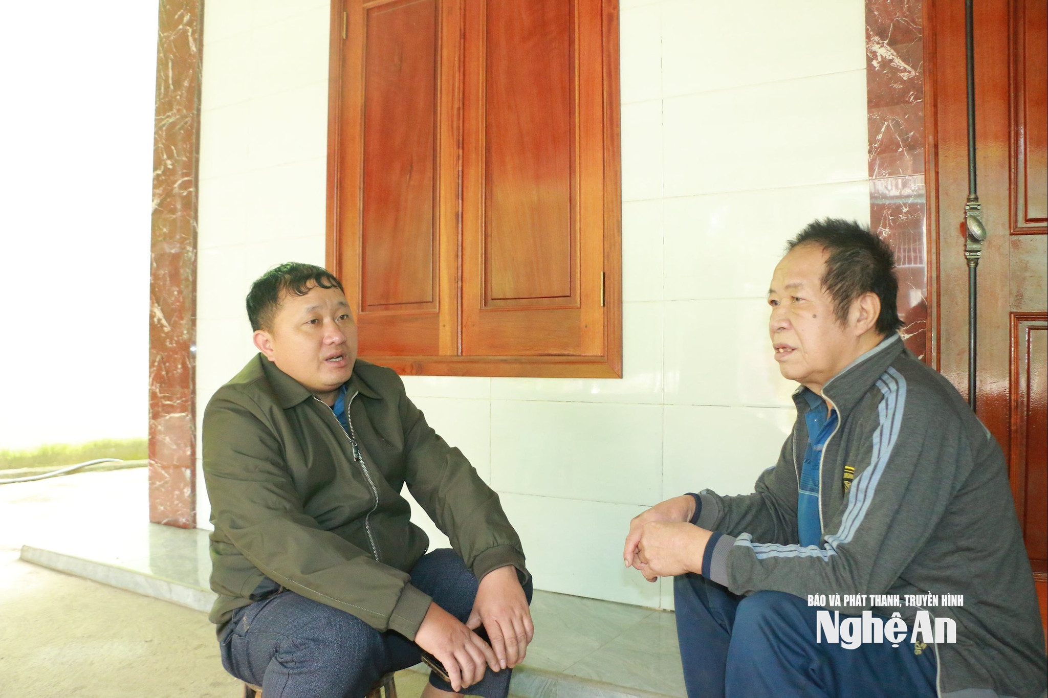 Bí thư Chi bộ kiêm Trưởng bản Hợp Thành Vừ Bá Xia (bên phải) trò chuyện với ông Lỳ Xìa Chớ (80 tuổi) – Trưởng dòng họ Lỳ. Ảnh KL