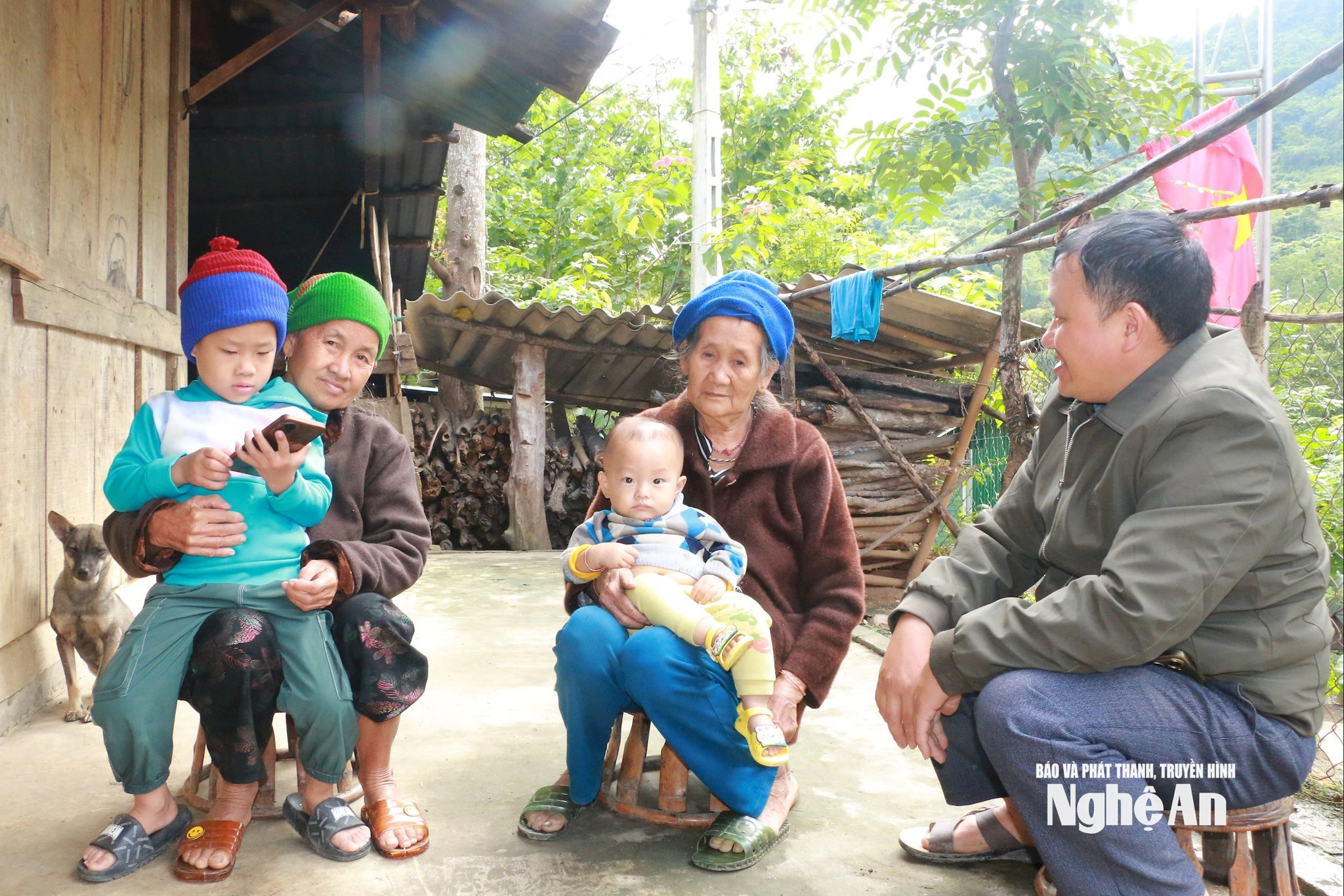 Bí thư Chi bộ kiêm Trưởng bản Vừ Bá Xia hỏi thăm người già trong bản có con đi làm ăn xa. Ảnh KL