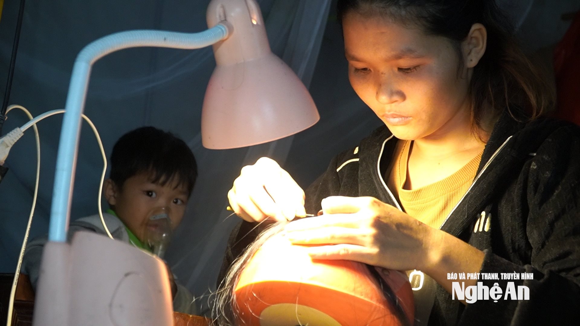 chị Hoàng Thị Nga làm nghề bện tóc giả nuôi chồng và con đau ốm. Ảnh Ngọc Dũng