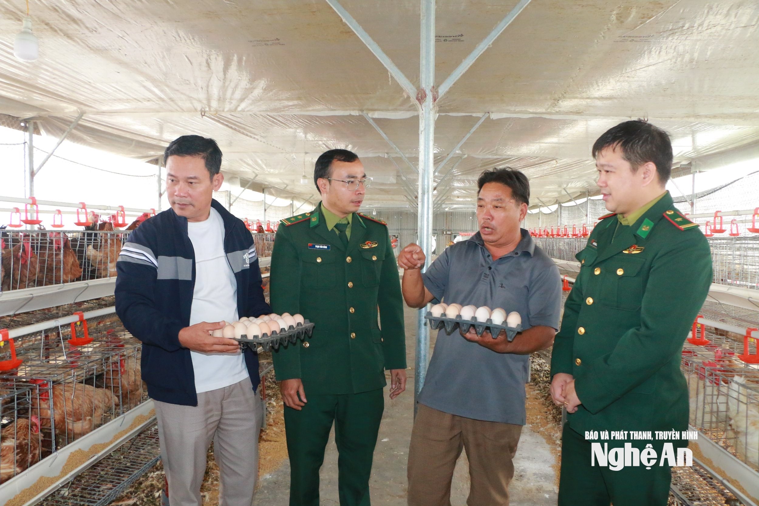 Đảng viên đồn biên phòng Diễn Thành trao đổi về kỹ thuật chăn nuôi gà siêu đẻ với hộ ông Lê Điện ( người thứ hai bên trái sang) xóm 5 xã Hải Châu. Ảnh KL