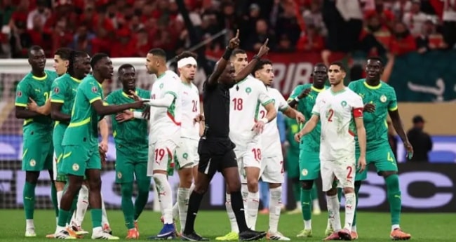 Các cầu thủ Senegal vây quanh trọng tài để phản đối quả phạt đền.
