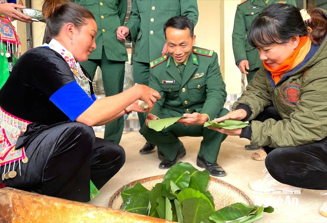 Cán bộ Đồn biên phòng Mỹ Lý gói bánh cùng người dân. Ảnh HT