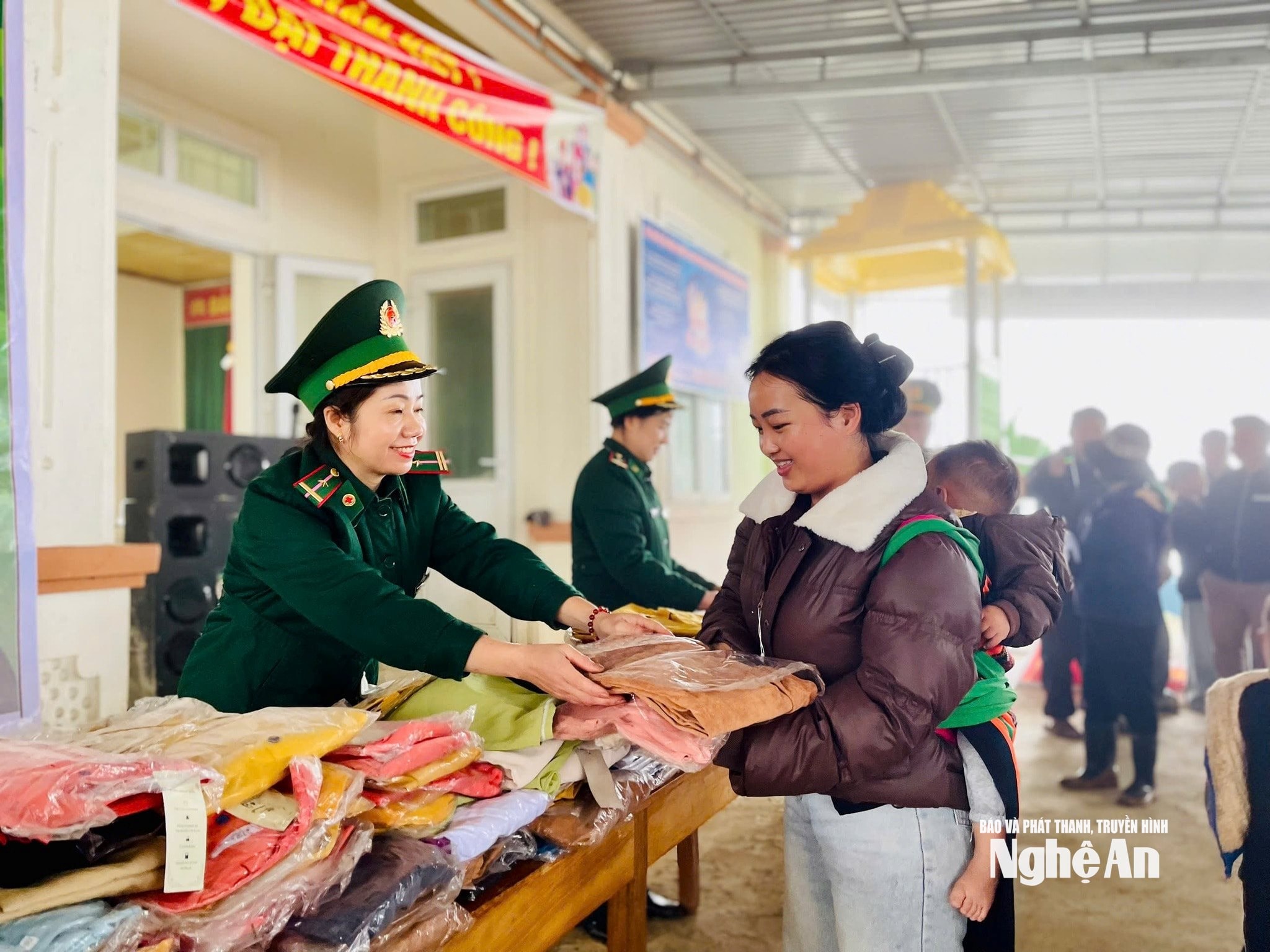 Cán bộ Đồn biên phòng Nậm Càn trao áo ấm cho người dân. Ảnh HT