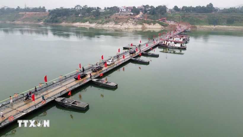 Người và phương tiện lưu thông bình thường qua cầu phao sông Lô sáng 16/2. (Ảnh: Nguyễn Văn Cảnh/TTXVN)