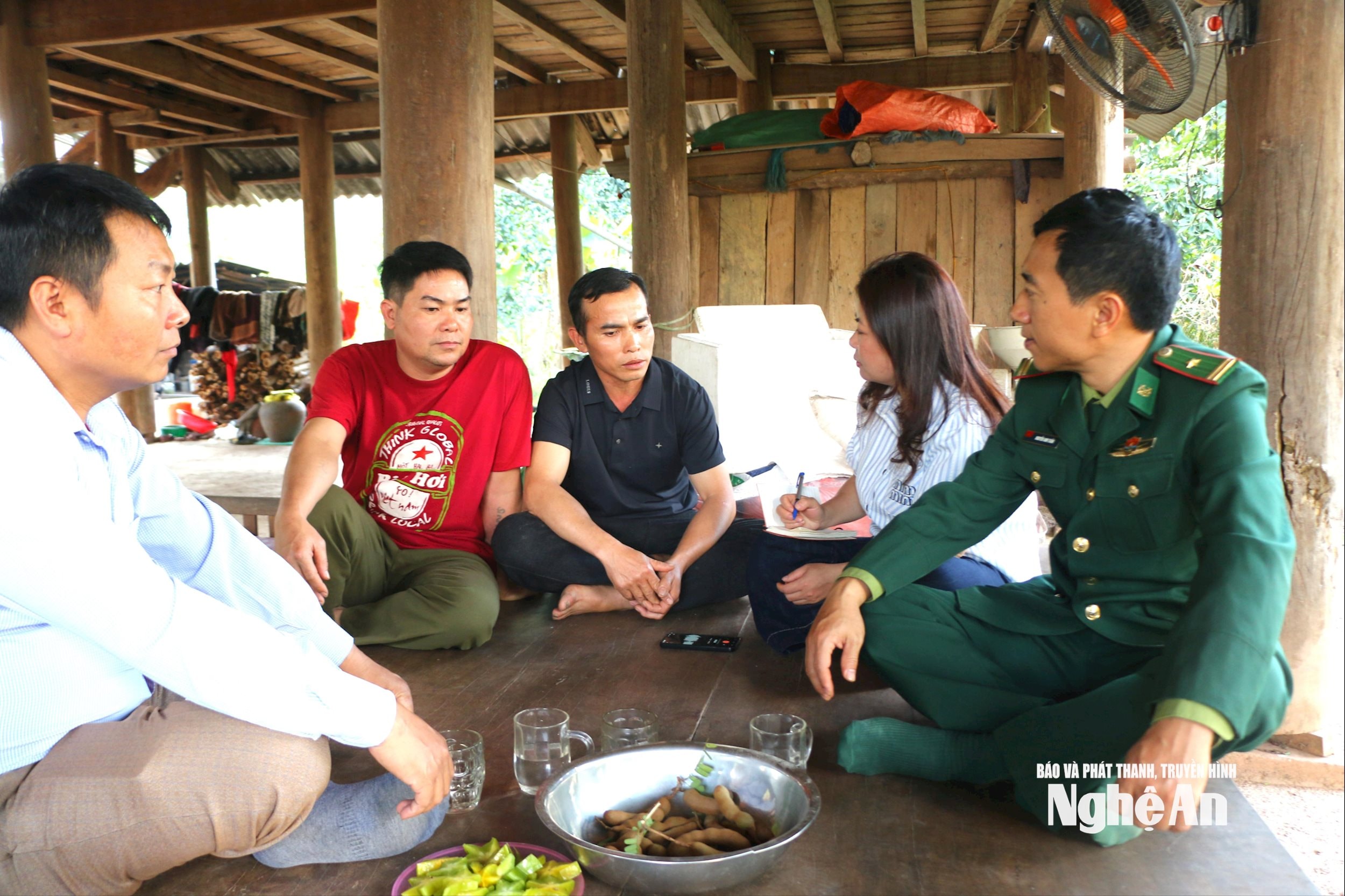 Anh Kha Văn Hiên ở bản Huồi Tố 1 trao đổi về quyết định viết đơn xin ra khỏi hộ nghèo. Ảnh KL