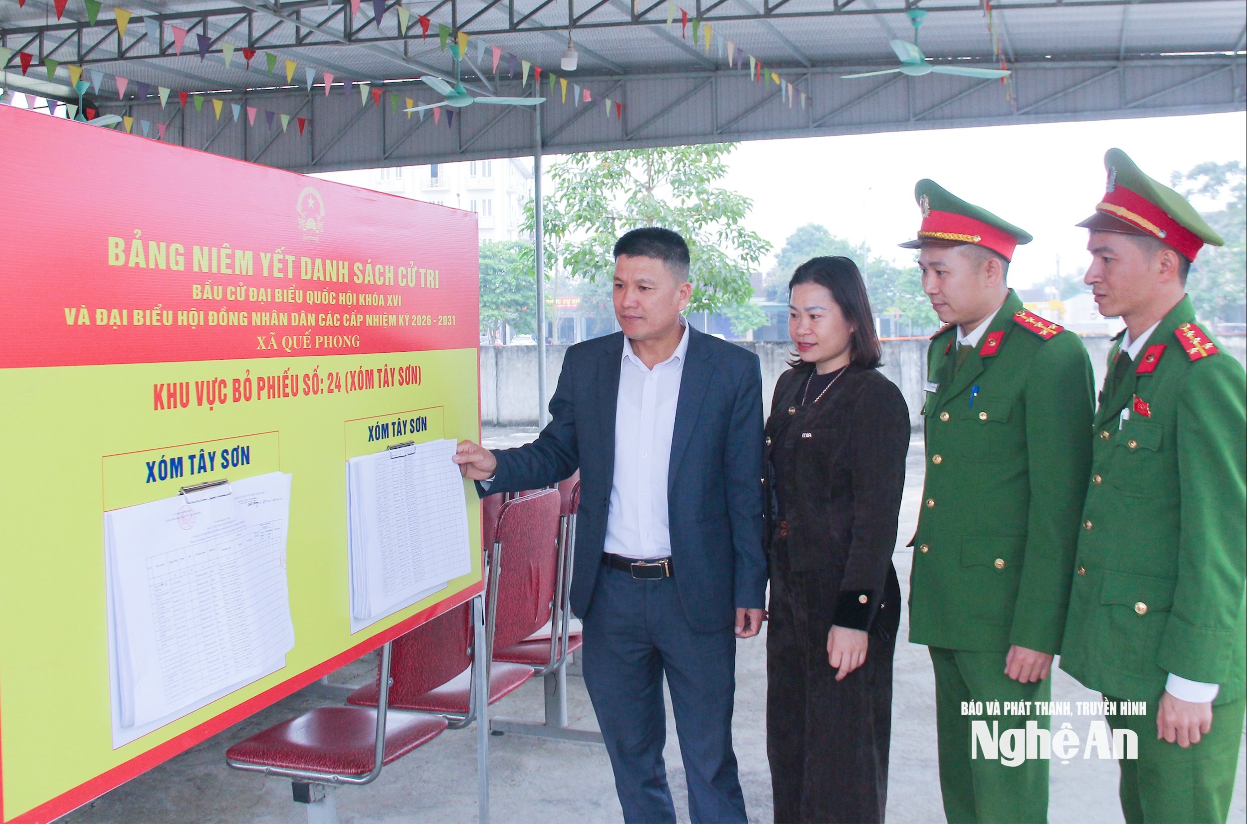  Cán bộ xã Quế Phong kiểm tra việc niêm yết danh sách cử tri tại khu dân cử. Ảnh- Mai Hoa