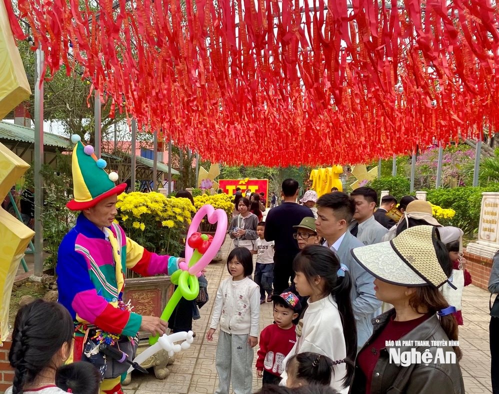 Trong khuôn viên đền - chùa Gám, những người mặc trang phục truyền thống khéo léo tạo hình bóng bay phục vụ các em nhỏ, góp phần làm không khí du xuân thêm rộn ràng. Ảnh: Văn Trường