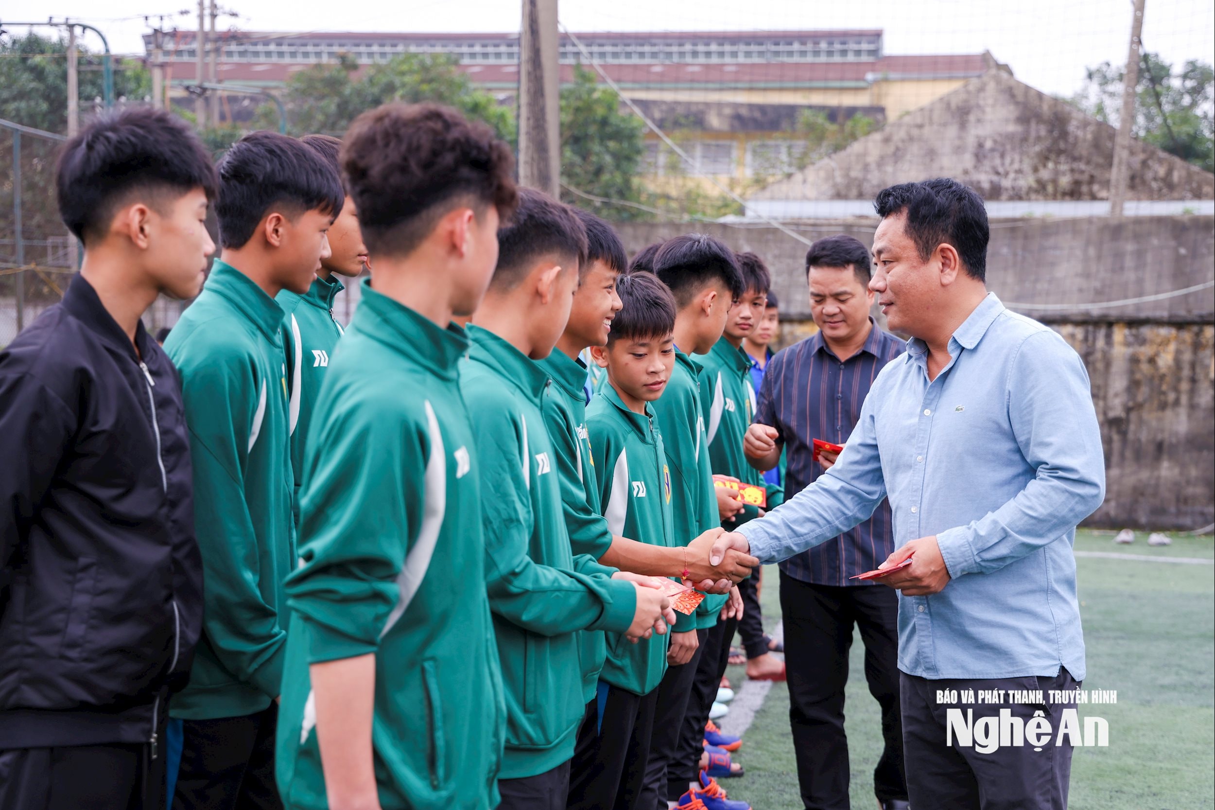 Ông Trần Quang Dũng lì xì cho các cầu thủ U15 SLNA II. Ảnh: Đức Anh