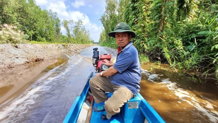 Ông Trương Văn Bảnh chuẩn bị thiết bị bảo hộ và kỹ thuật lấy mật ong rừng.