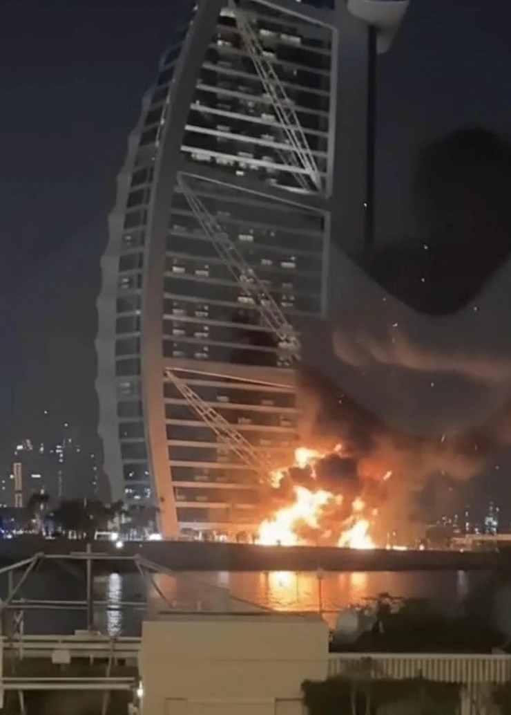 Ngọn lửa bùng phát tại khu vực bên ngoài khách sạn Burj Al Arab sau khi mảnh vỡ máy bay rơi xuống.
