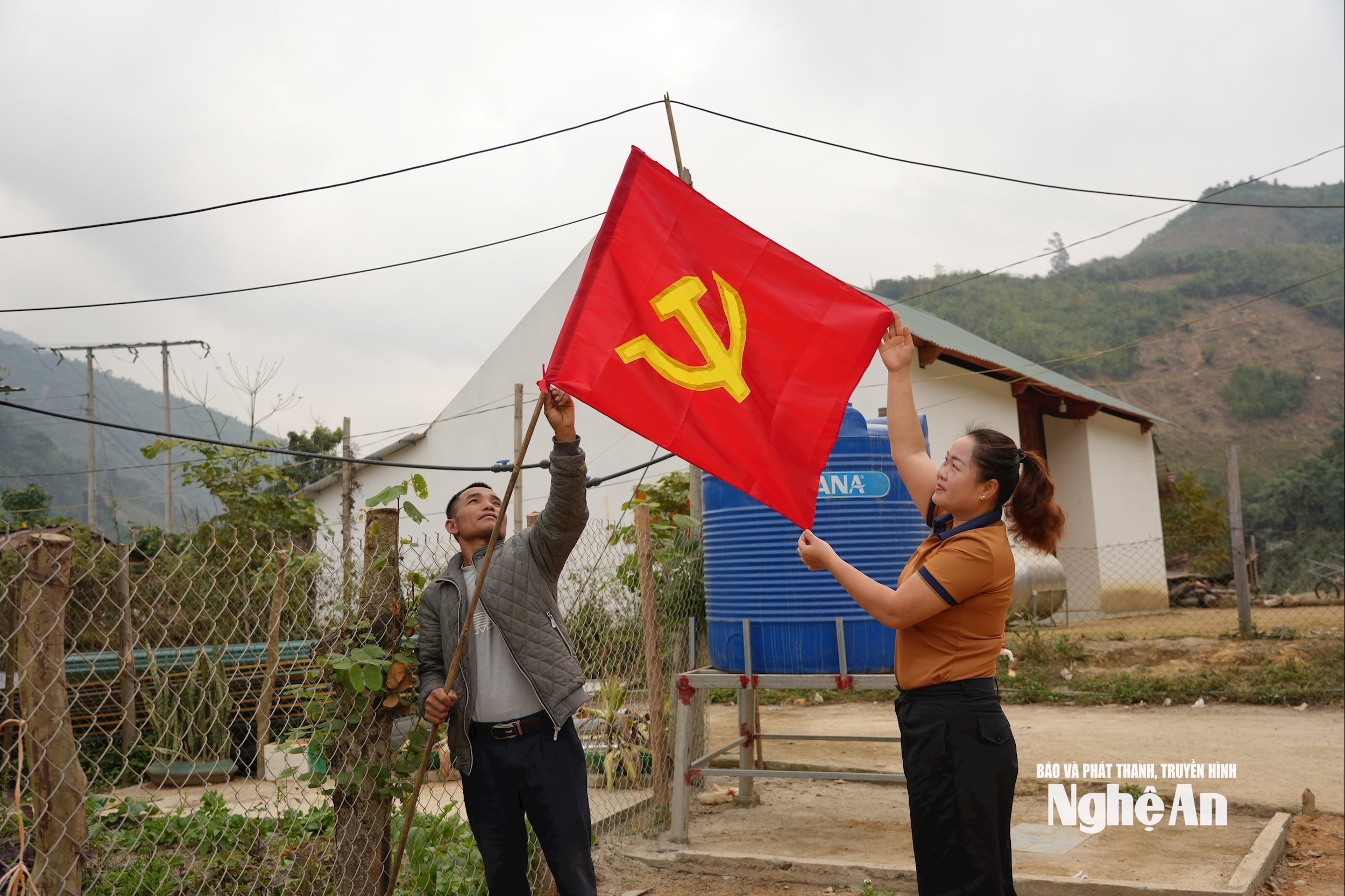 Người dân xã Nhôn Mai treo cờ chuẩn bị cho ngày hội non sông. Ảnh GH