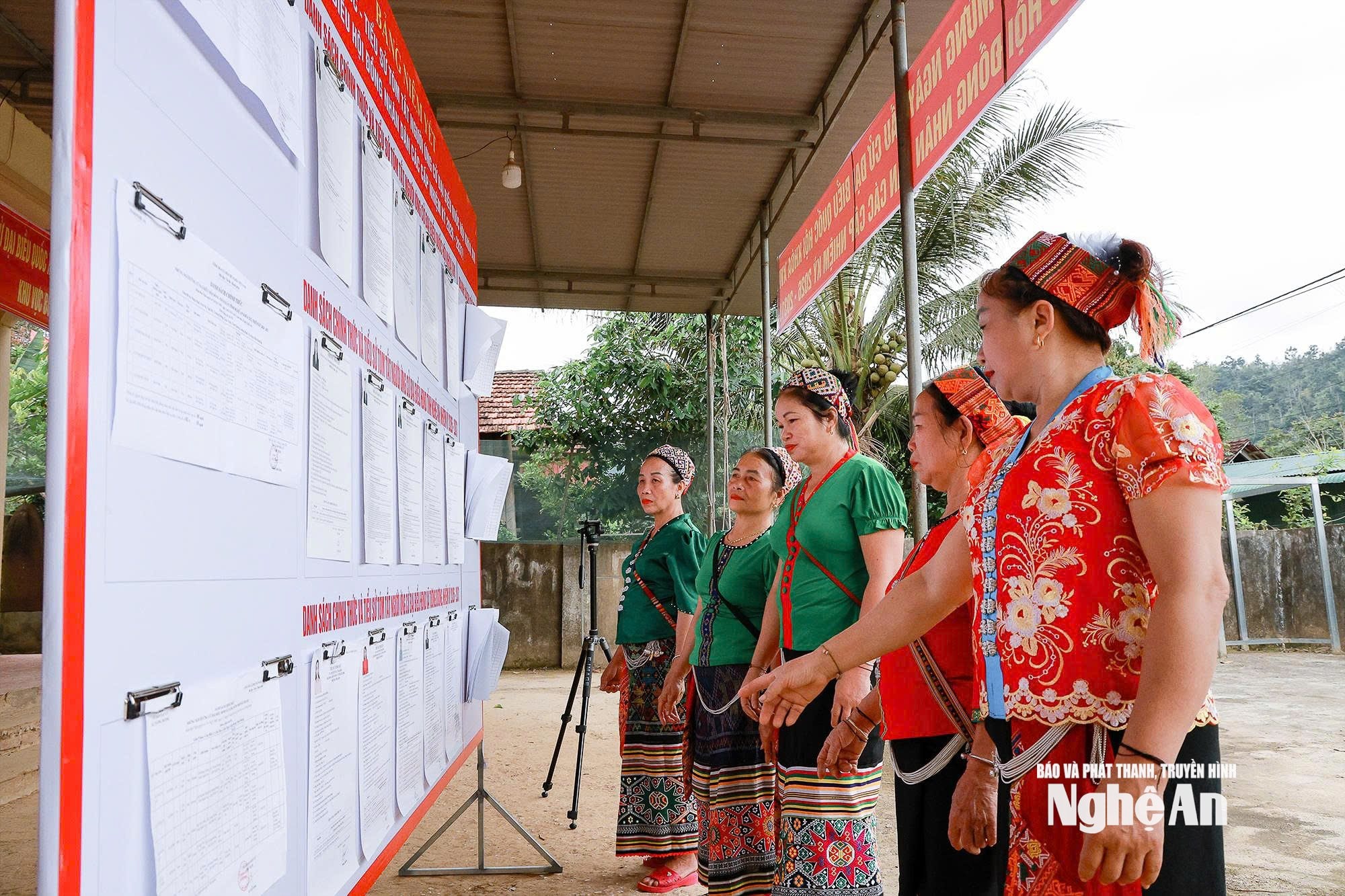 Người dân tìm hiểu thông tin ứng viên ứng cử Đại biểu Quốc hội và HĐND các cấp tại điểm bầu cử bản Mon, xã Tương Dương. Ảnh Đình Tuân