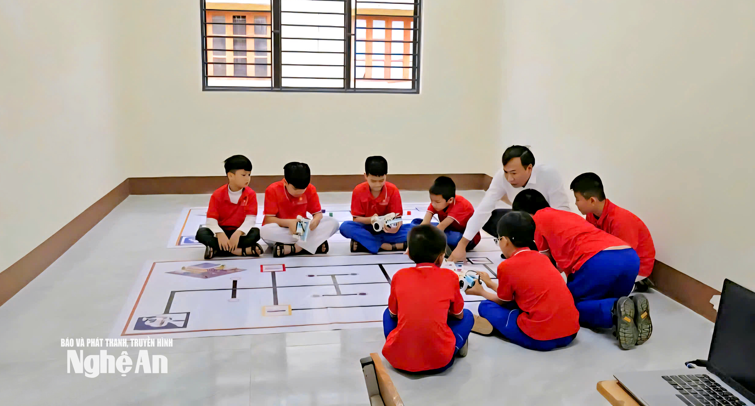 Thầy Nguyễn Như Phùng cùng các em học sinh Trường Tiểu học 1 Trà Lân, xã Con Cuông trong 1 tiết học về robotics