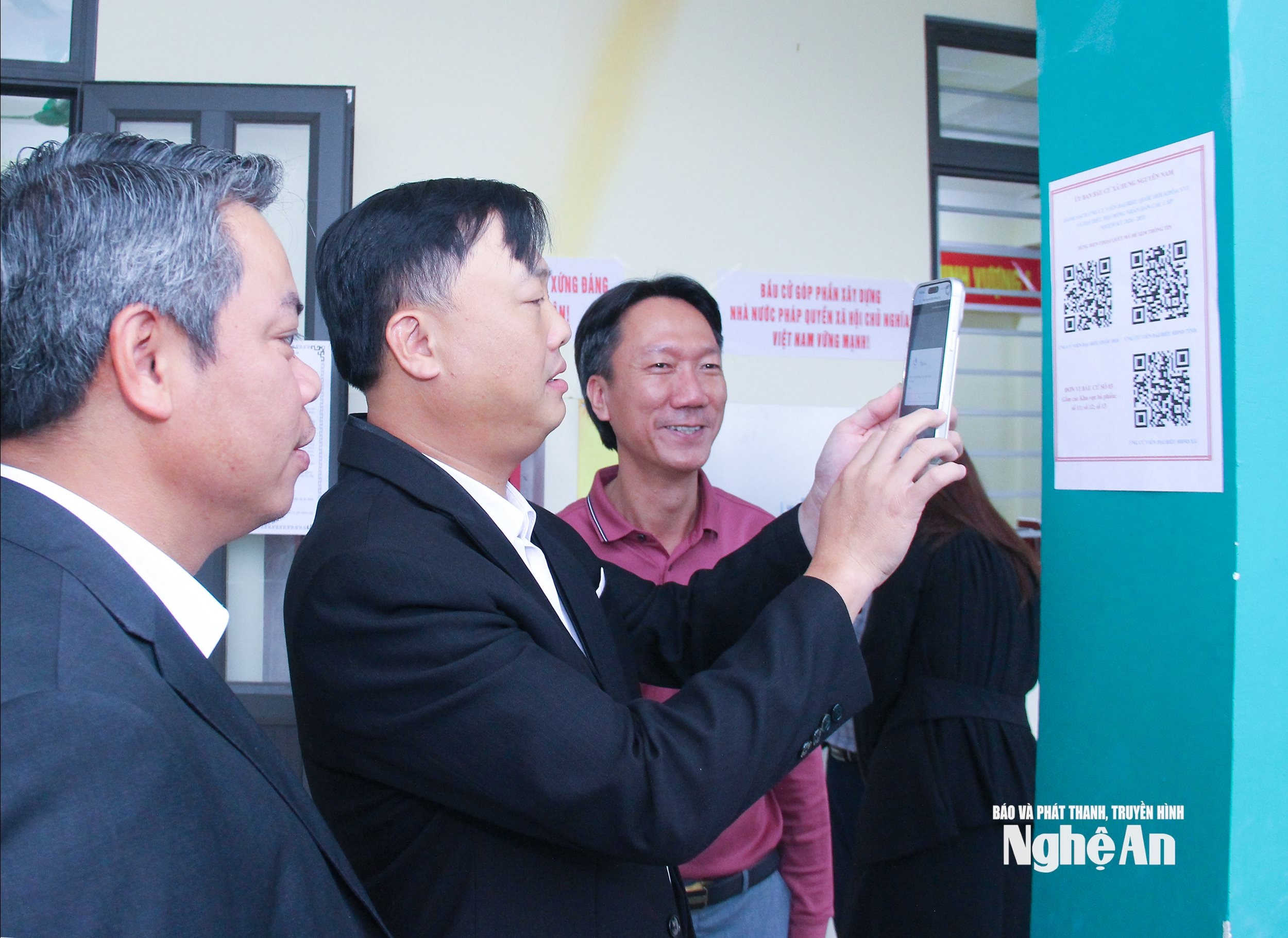  Cán bộ xã Hưng Nguyên Nam kiểm tra mã QR về danh sách và tiểu sử những người ứng cử được gián tại khu vục bỏ phiếu. Ảnh Mai Hoa