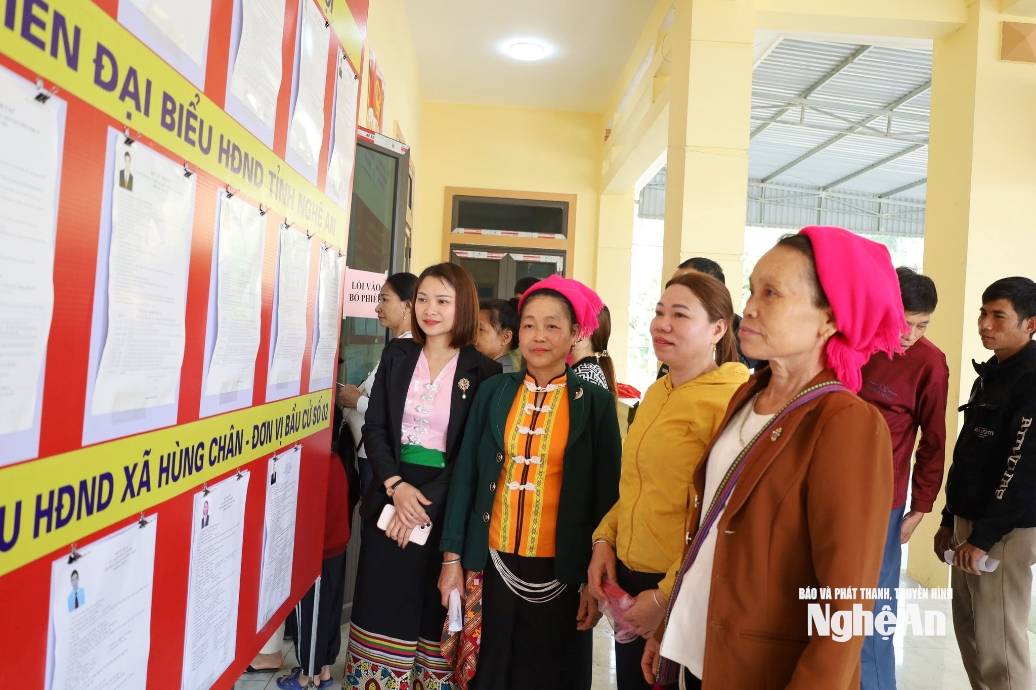 Cử tri xã Hùng Chân xem thông tin các ứng cử viên trước khi bỏ phiếu. Ảnh Mai Hoa