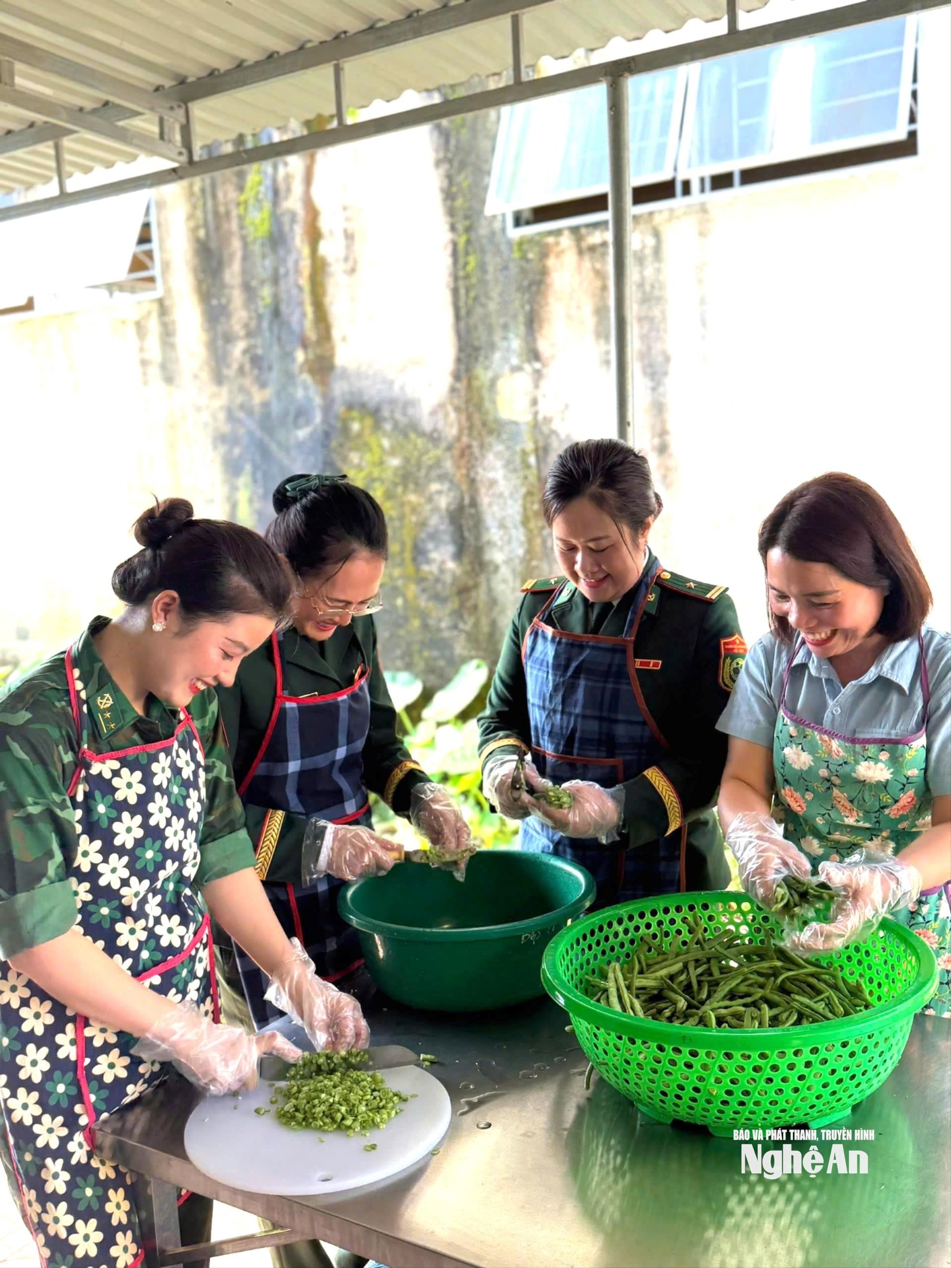 Cán bộ, hội viên phụ nữ biên phòng cùng các cô giáo chuẩn bị bữa ăn dinh dưỡng cho học sinh mầm non Môn Sơn. Ảnh AB