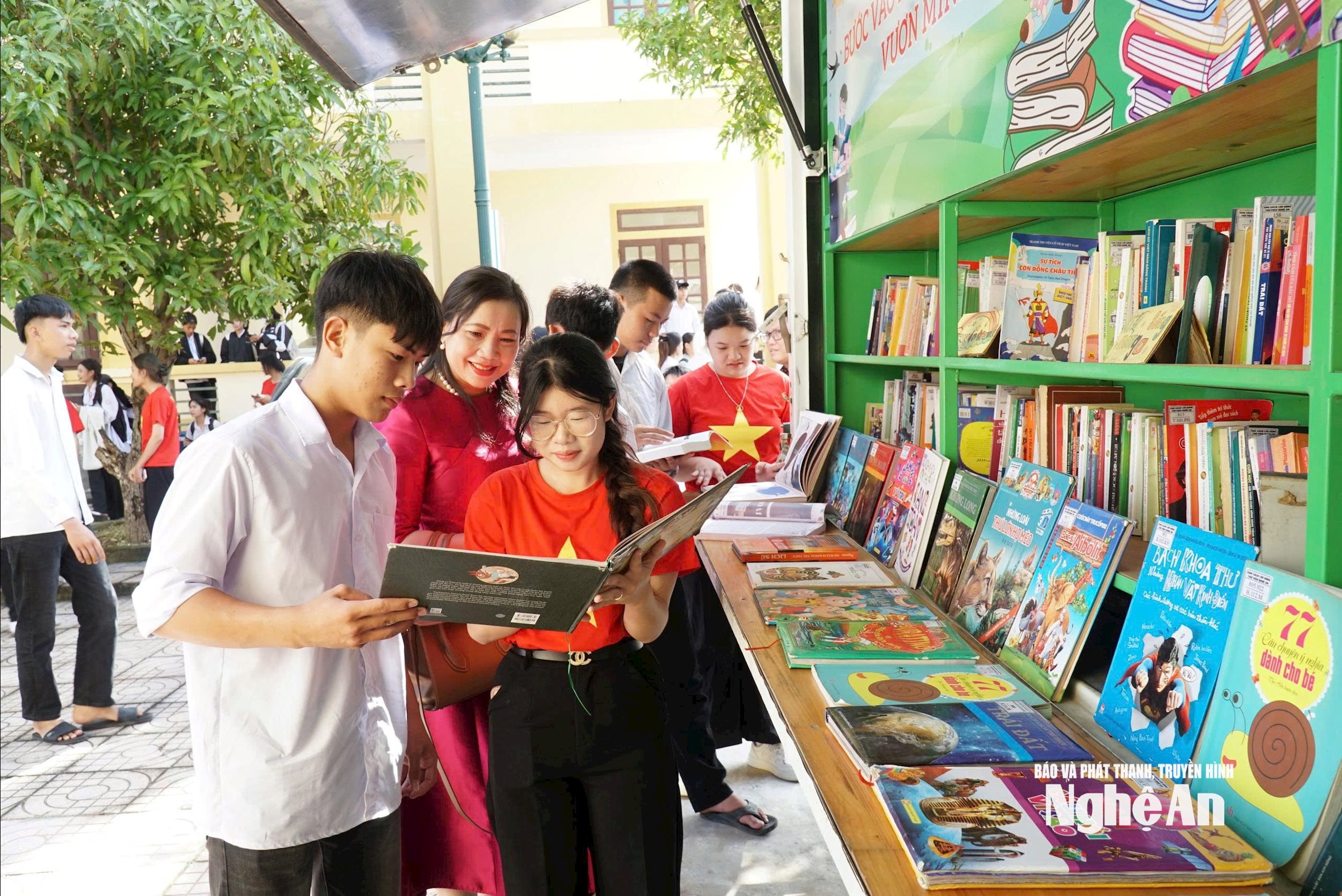 Các học sinh đọc sách tại Gian hàng Tủ sách Thư viện di động. Ảnh Mỹ Hà