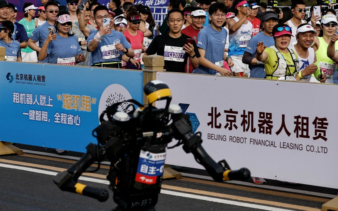 Đám đông quan sát robot chạy đua trên đường phố