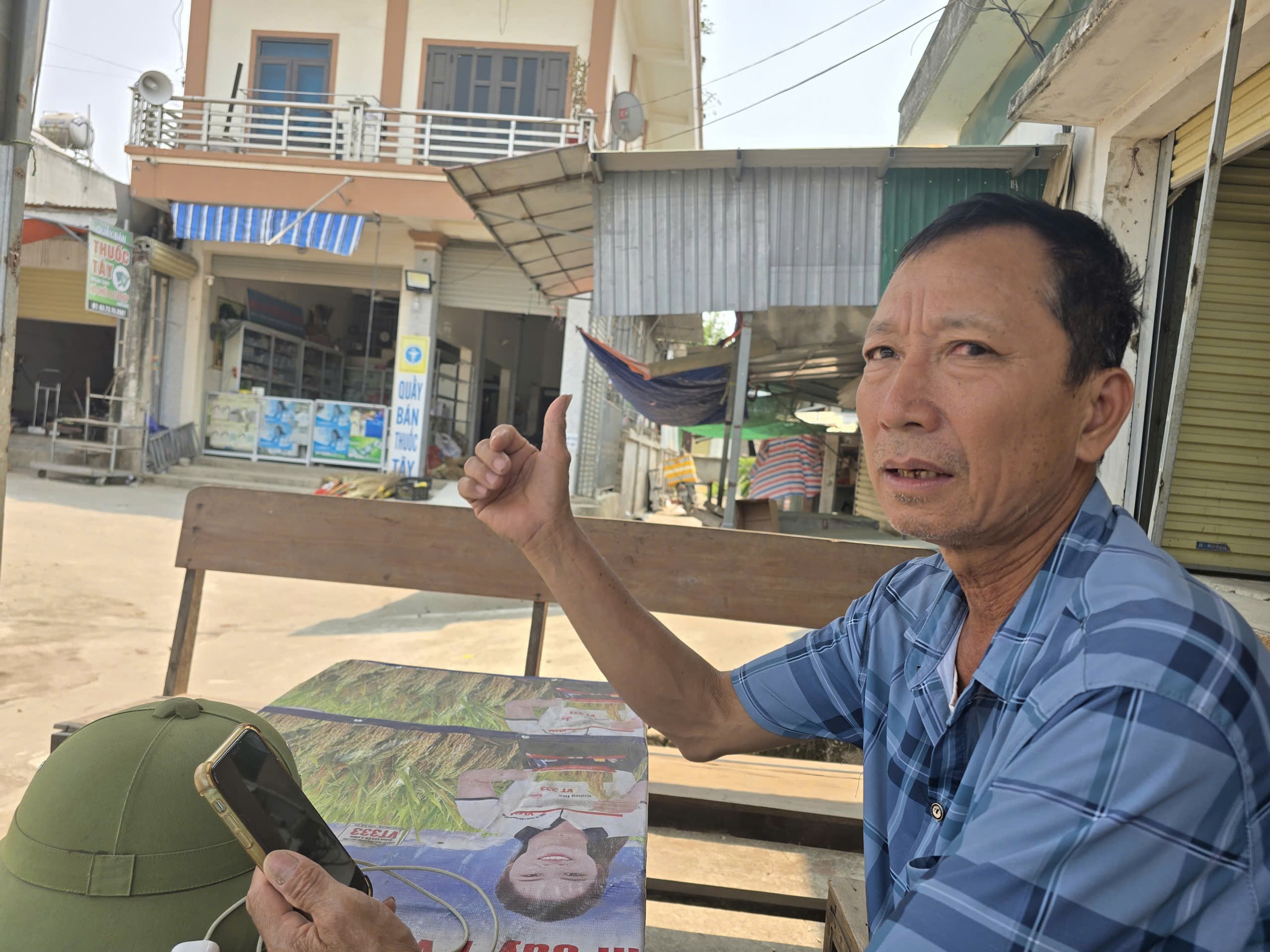 Ông Thao ngồi thất thần trước cổng chợ Tân Thành, kể về hành trình tìm chủ phường trong vô vọng. Ảnh: Tiến Hùng