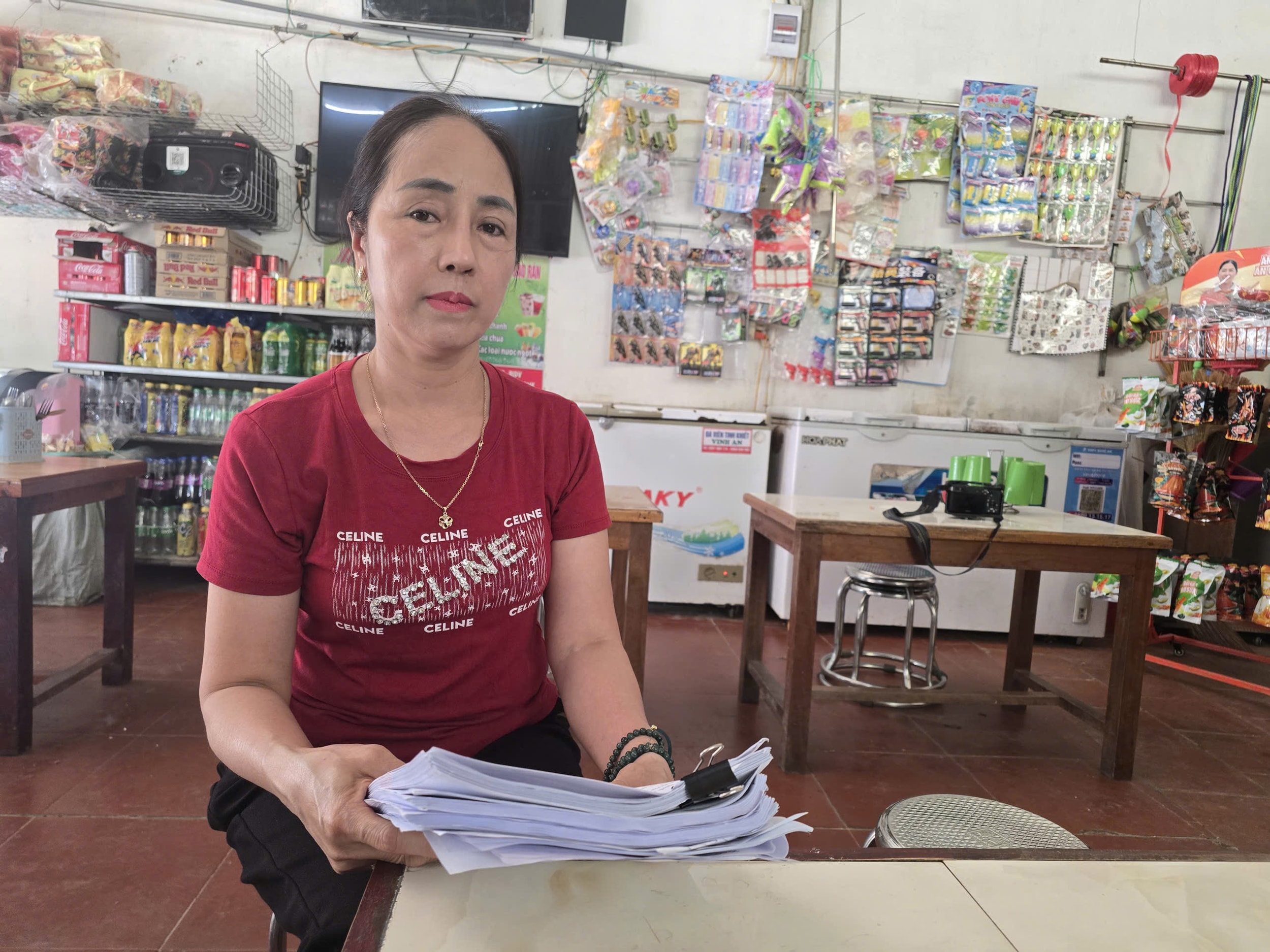 Bà Hậu cầm trên xập tài liệu sao kê những lần chuyển tiền cho chủ phường. Ảnh: Tiến Hùng