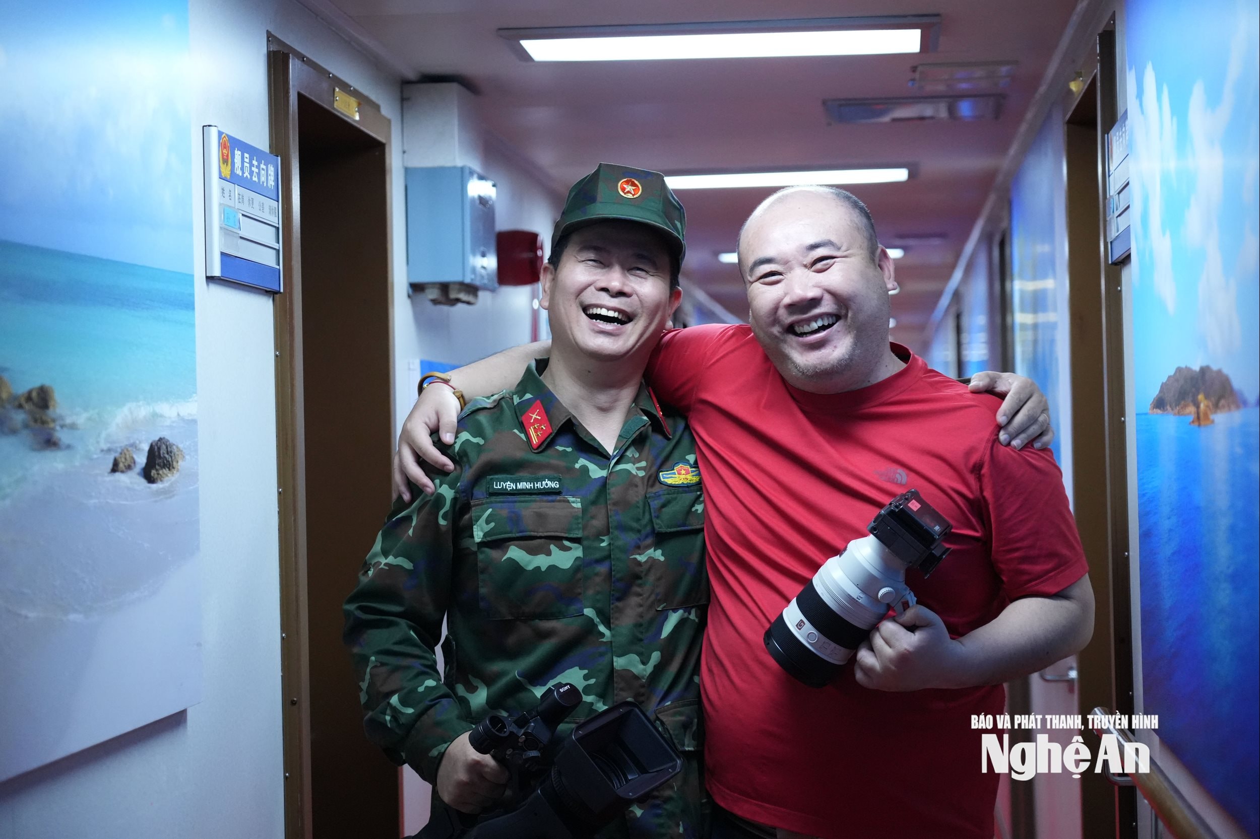 Thượng tá - phóng viên Luyện Minh Hưởng (trái) Kênh truyền hình Quân đội và phóng viên người Trung Quốc trong một bức hình