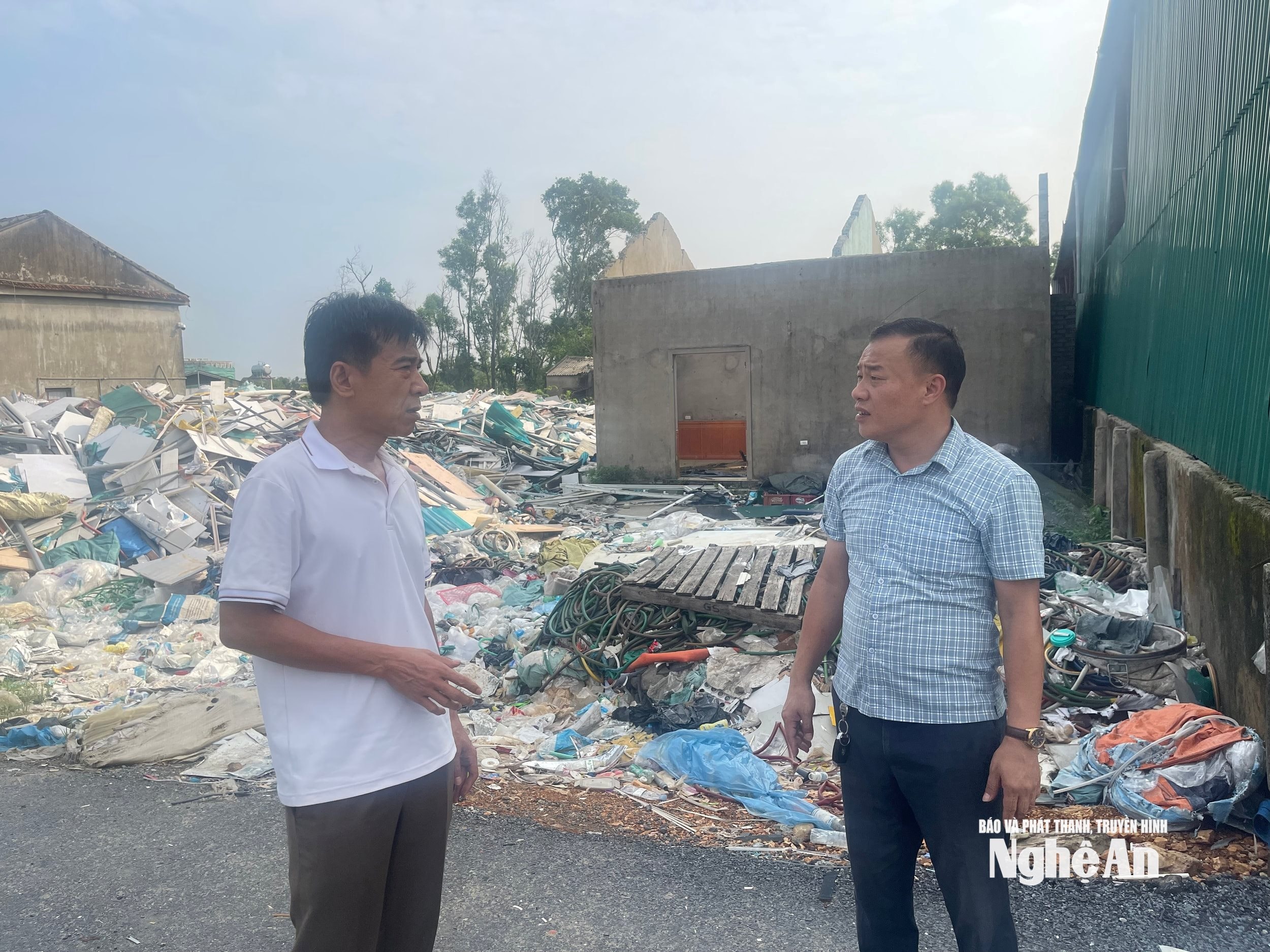 Ông Lê Văn Thu (bên phải) - Khối trưởng khối 9 Nghi Phong, phường Vinh Lộc trao đổi với P V tại khu vực tập kết phế liệu. Ảnh Tiến Đông