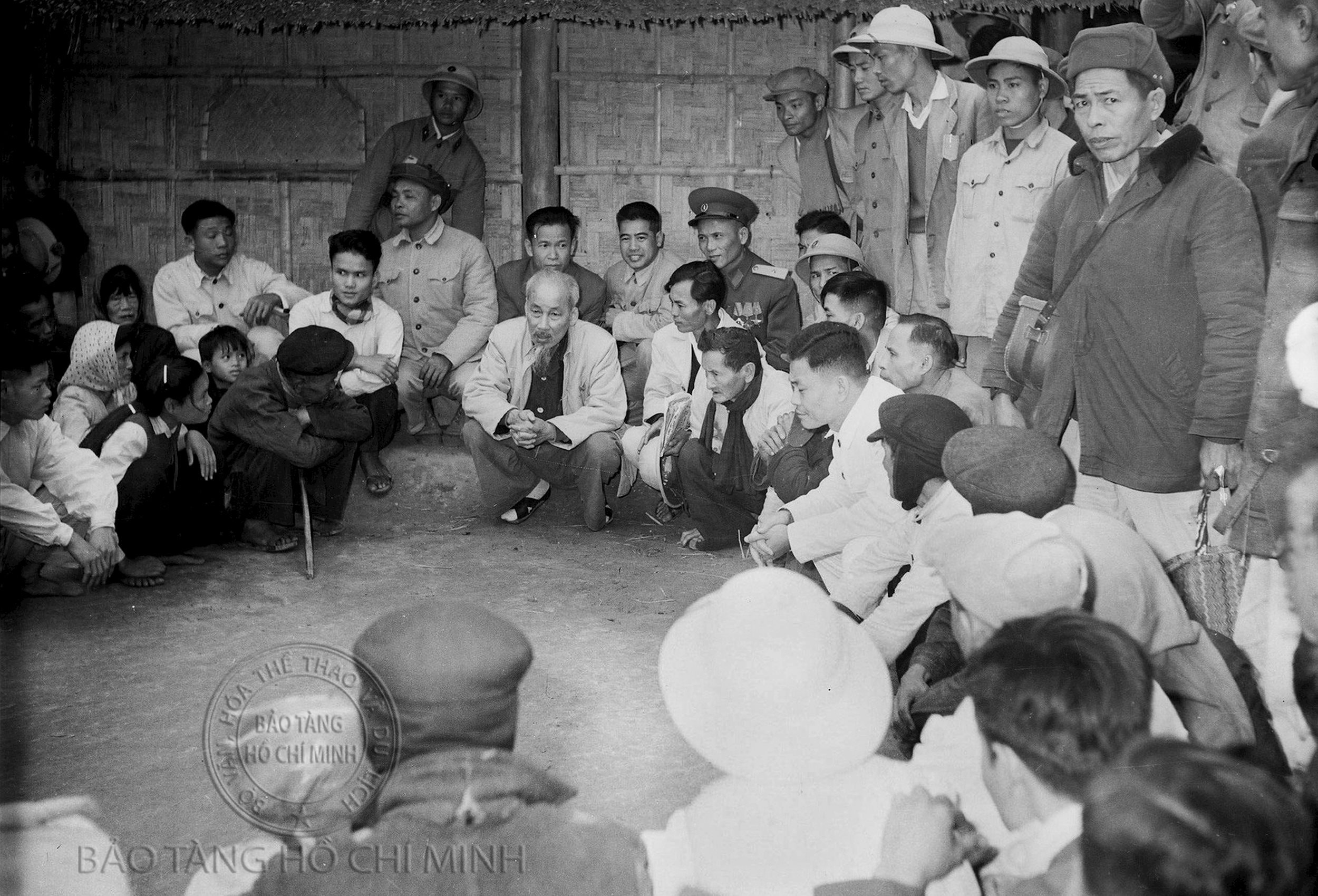 Chủ tịch Hồ Chí Minh ngồi nói chuyện với nhân dân trước ngôi nhà nơi sinh ra Người ở làng Hoàng Trù ngày 9/12/1961. Ảnh tư liệu - Khu Di tích Kim Liên