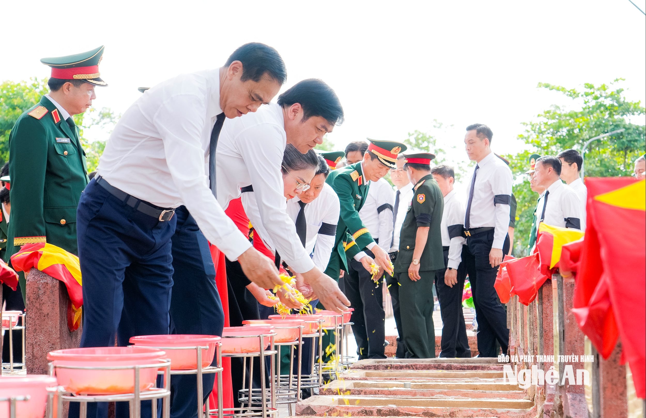 Các đại biểu thực hiện nghi lễ rải hoa ở các phần mộ liệt sĩ. Ảnh: Phạm Bằng