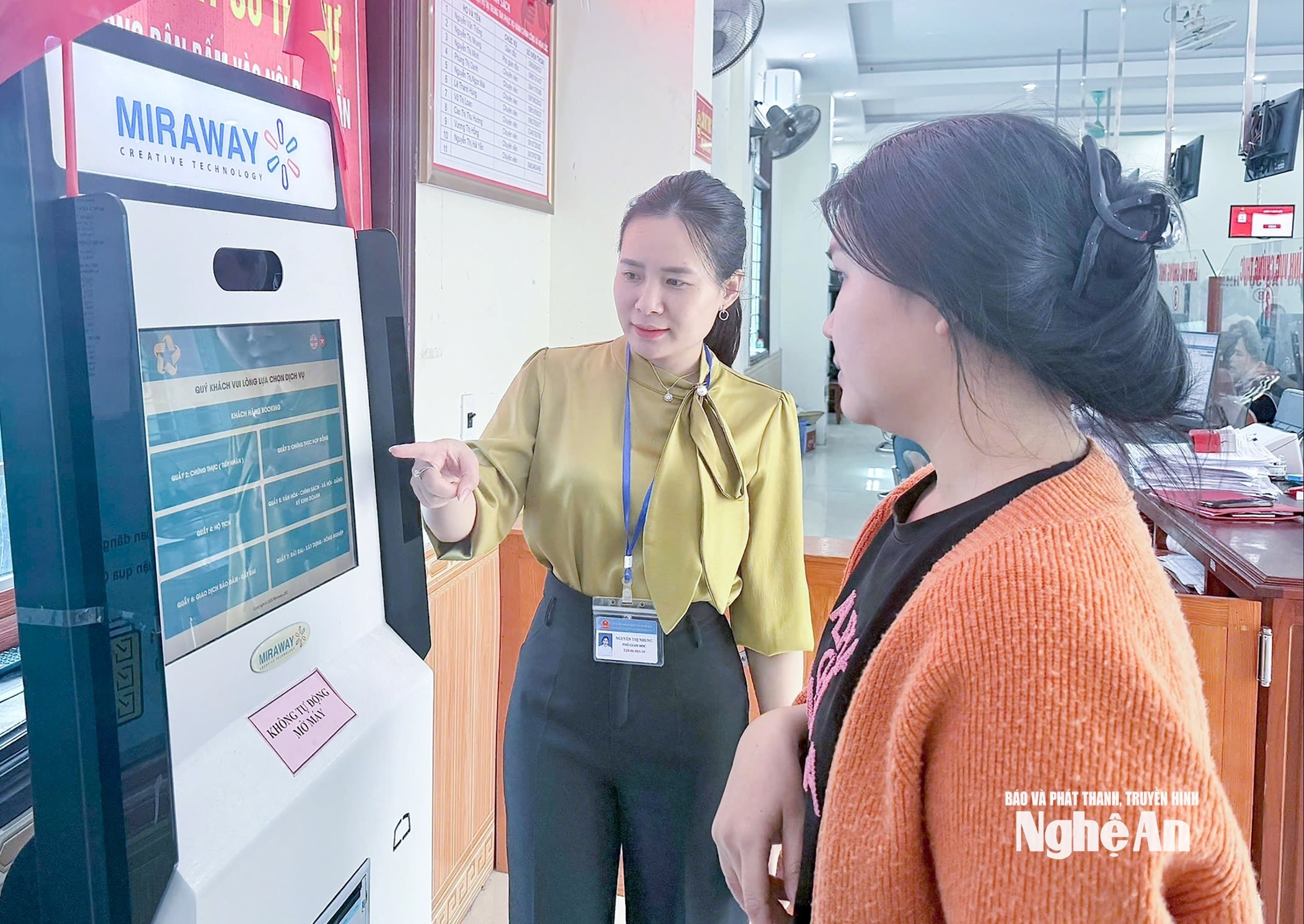 Cán bộ Trung tâm Phục vụ hành chính công xã Nghi Lộc hướng dẫn người dân lấy số thứ tự giải quyết thủ tục hành chính. Ảnh: MH