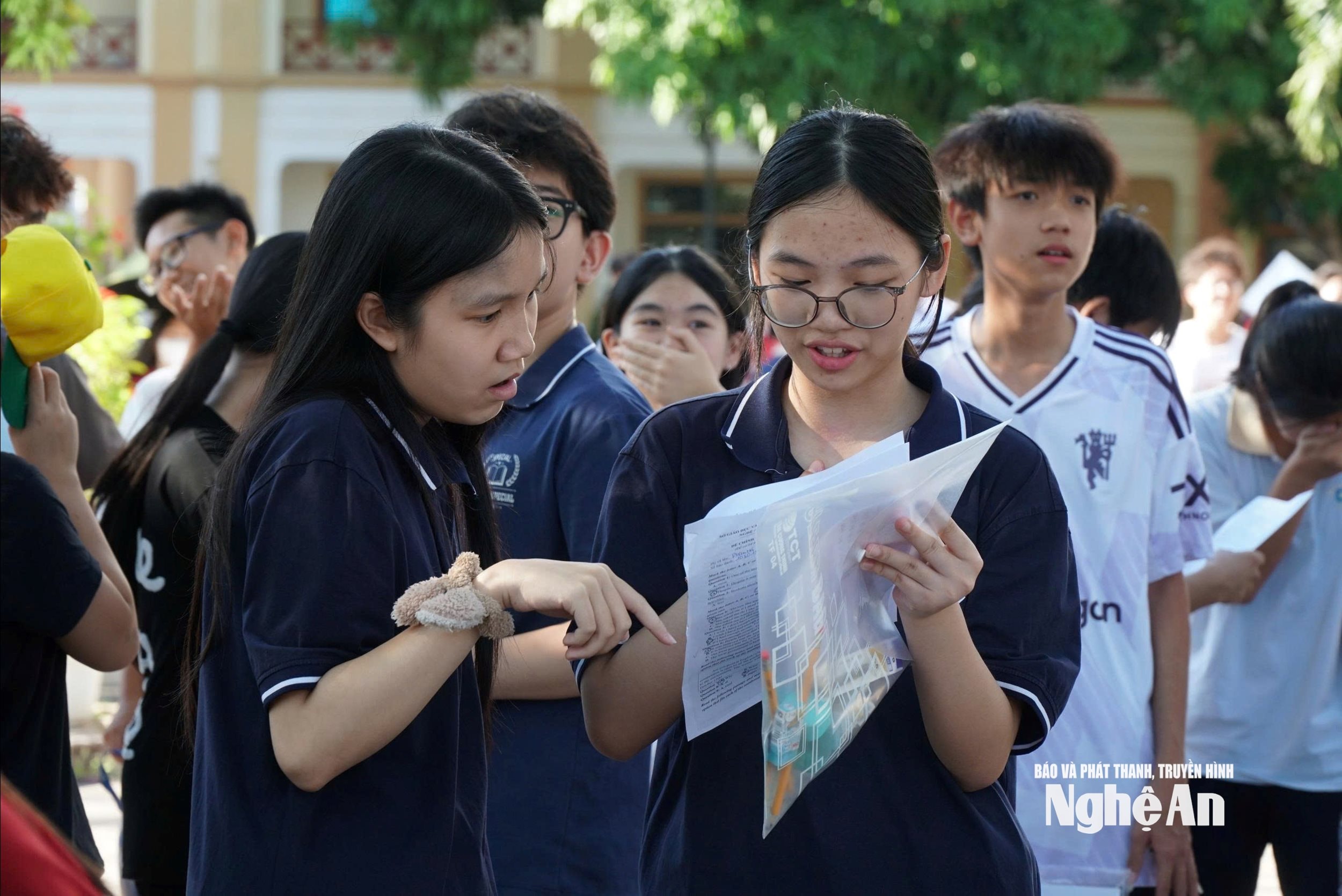 Các thí sinh nán lại sau giờ thi để kiểm tra lại đáp án. Ảnh - Mỹ Hà