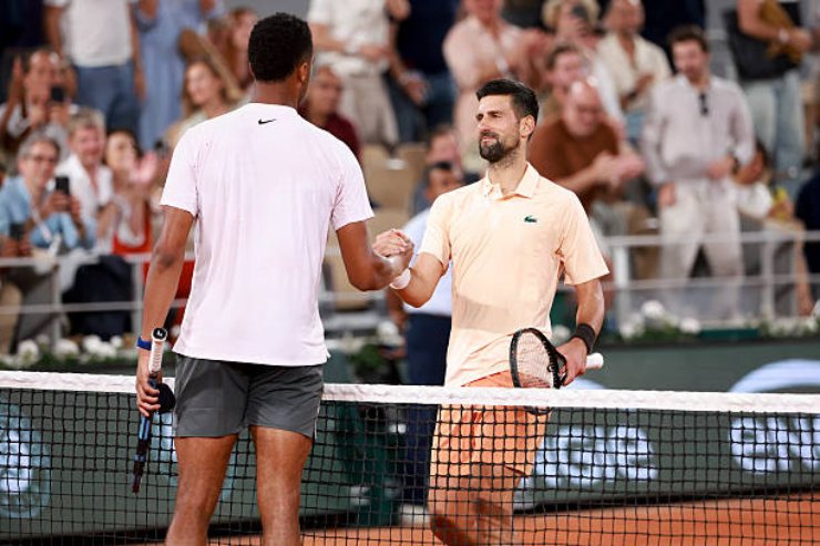 Djokovic (bên phải) tìm ra cách giải mã máy giao bóng Perricard sau khi thua set đầu tiên.