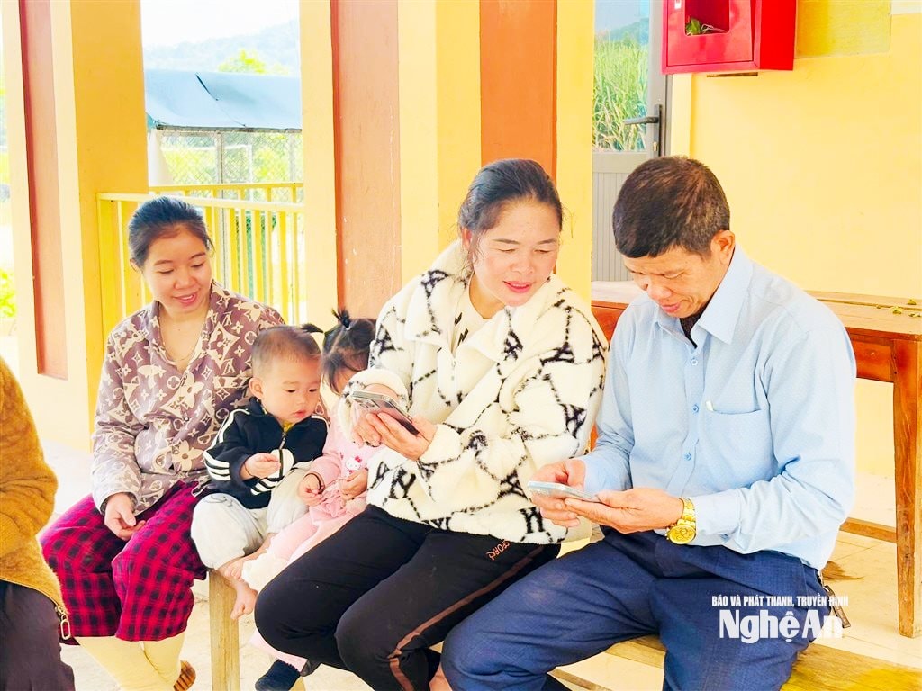 Cán bộ làng Mai Thái hướng dẫn bà con vào mạng xem tin tức. Ảnh Minh Thái
