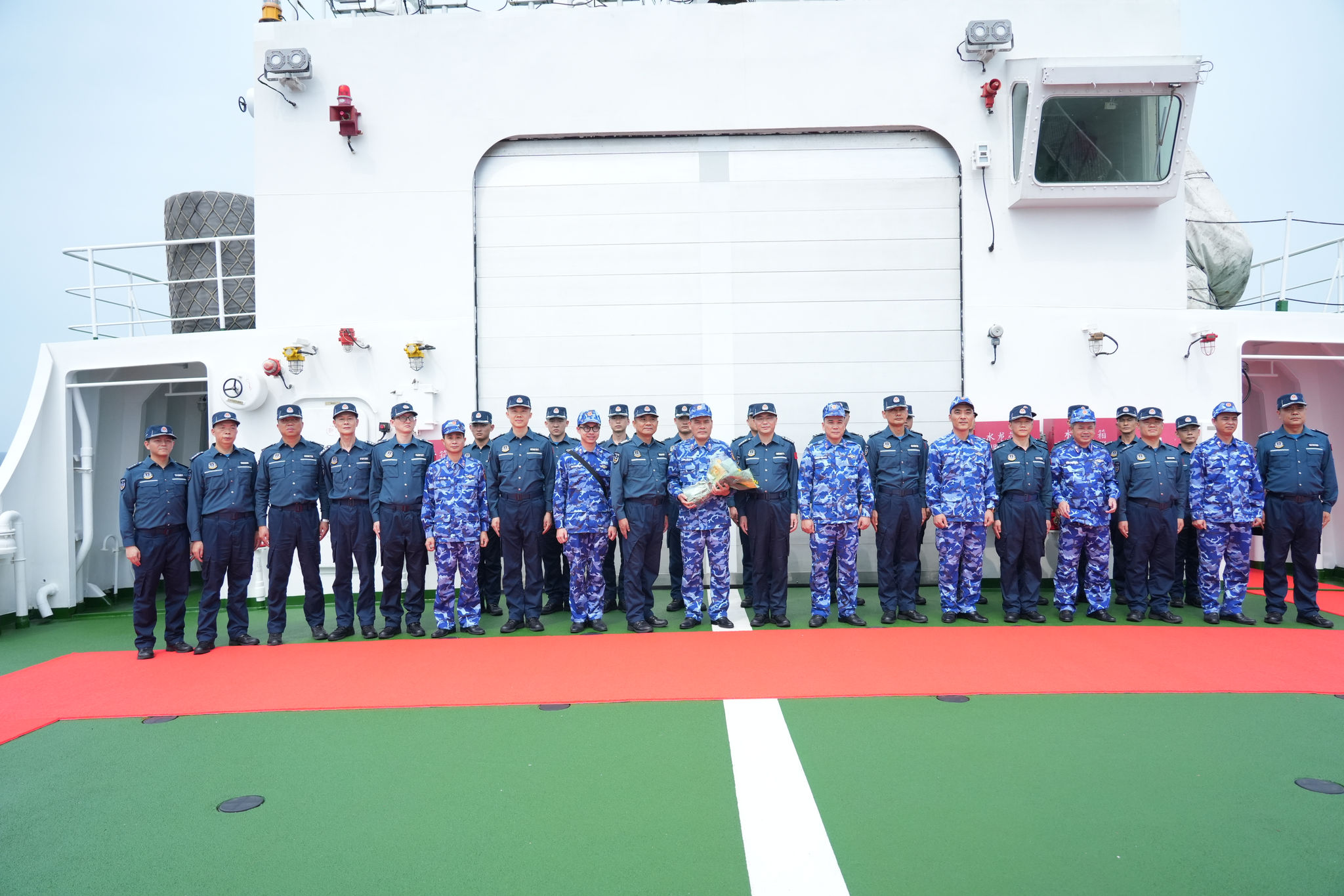 Les délégations des garde-côtes vietnamiens et chinois posent pour une photo commémorative.