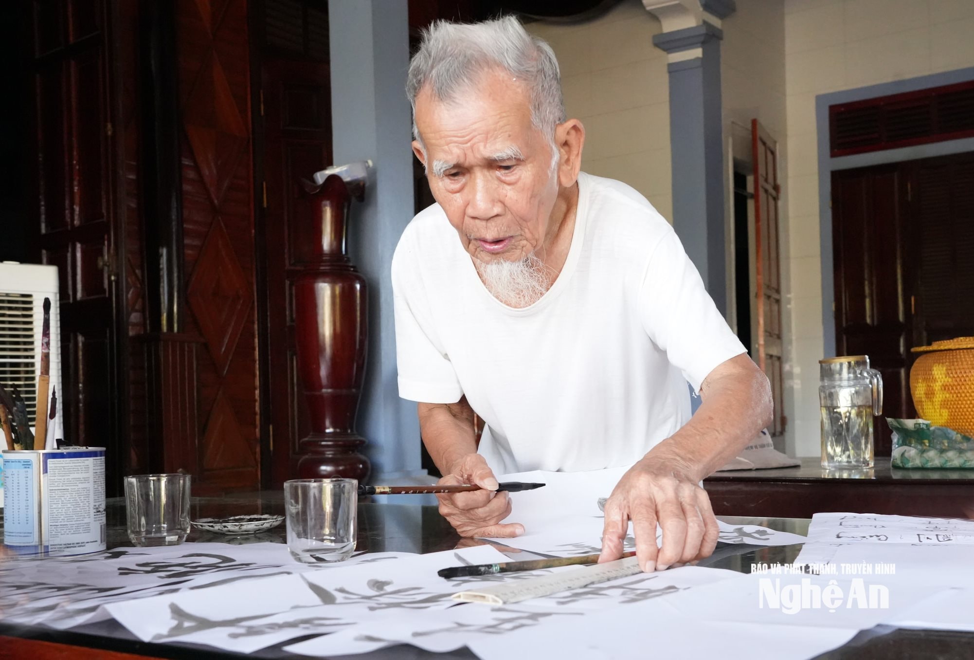 Cụ Nguyễn Tú Châu, 103 tuổi đang viết câu đối bằng chữ Hán. Ảnh TP