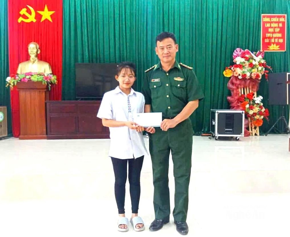 Thượng tá Nguyễn Ngọc Tú- Chính trị viên Đồn biên phòng Keng Đu trao quà hỗ trợ cho con nuôi biên phòng.