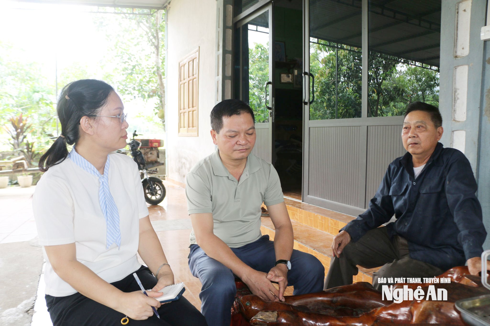 Ông Ngân Đình Phòng (áo đen) ở bản Boong chia sẻ về quyết định hiến đất mở đường. Ảnh KL