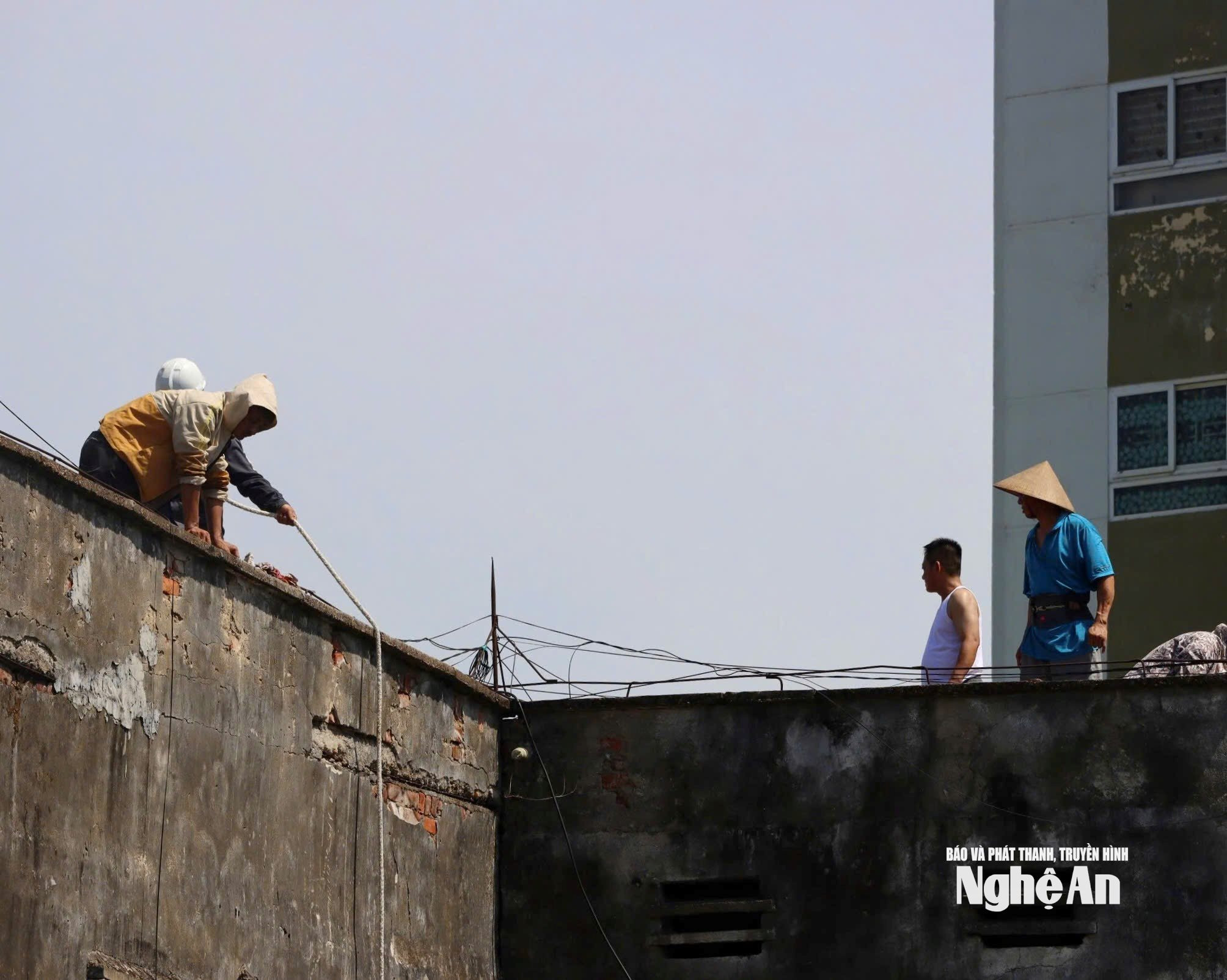 Nhiều người dân sử dụng dây kéo để đưa đồ từ trên cao xuống. Ảnh: Diệp Thanh