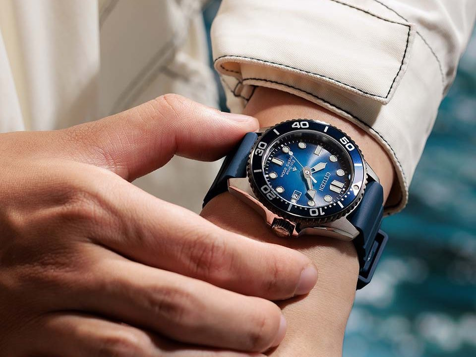 Người đeo Citizen Promaster Marine BN0267-04L với mặt số chuyển sắc xanh dương và dây đeo xanh dương trên cổ tay.