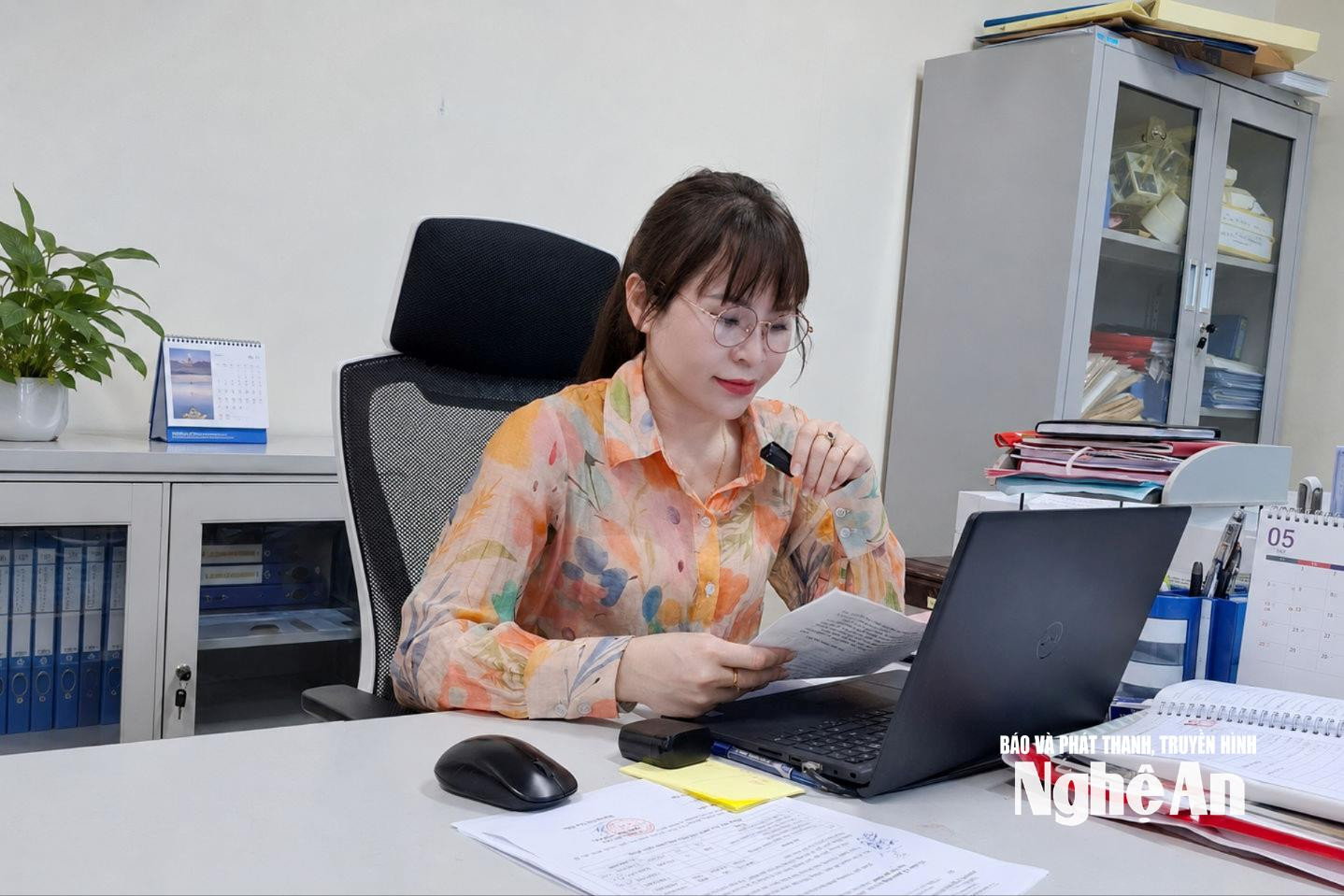 السيدة دانغ ثي نغا، مسؤولة الثقافة في بلدية آن تشاو، تقرأ نشرة أخبار البلدية.