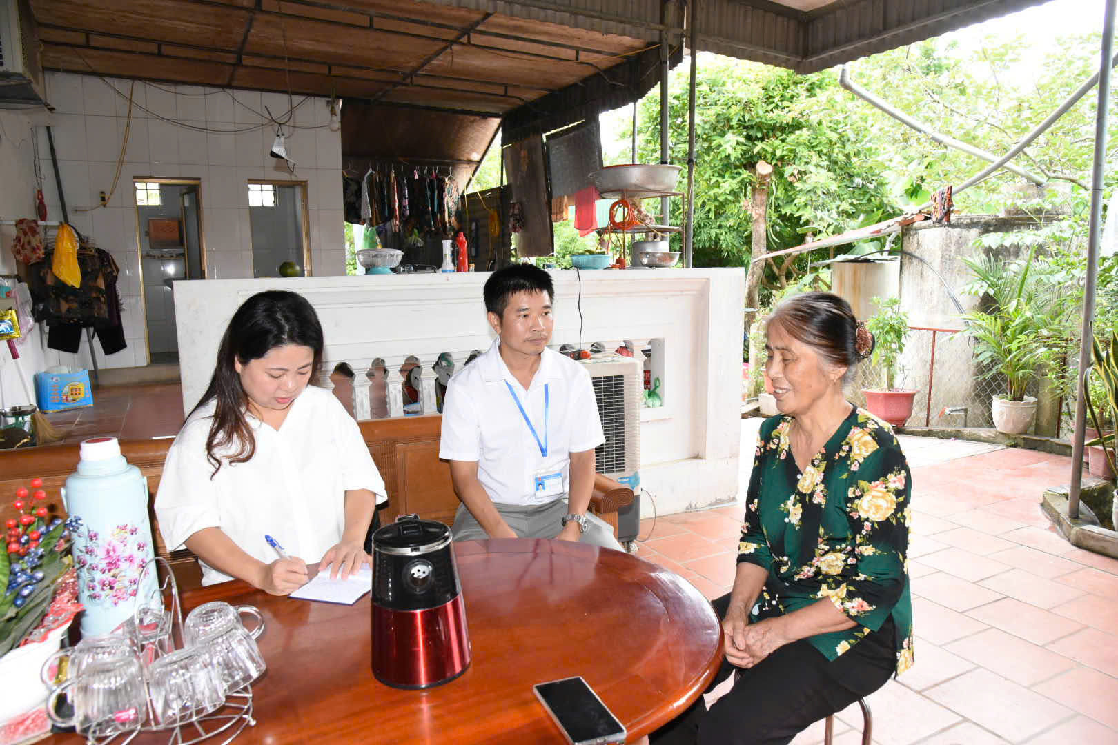 Bà Nguyễn Thị Nhâm chia sẻ niềm vui với cán bôn TT hành chính công xã Lam Thành và PV Báo và THTH Nghệ An về việc được giúp đỡ lam thử tục sang tên bìa đất cho con trai