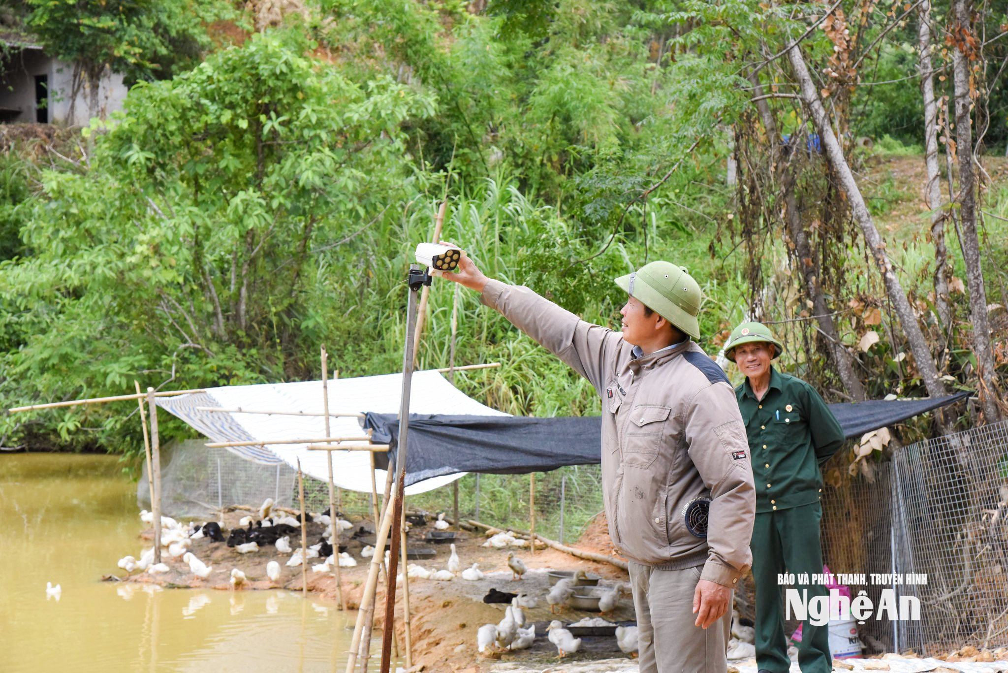 Anh Nguyễn Hồng Kỳ lắp đặt hệ thống camera giám sát xung quanh trang trại. Ảnh HT