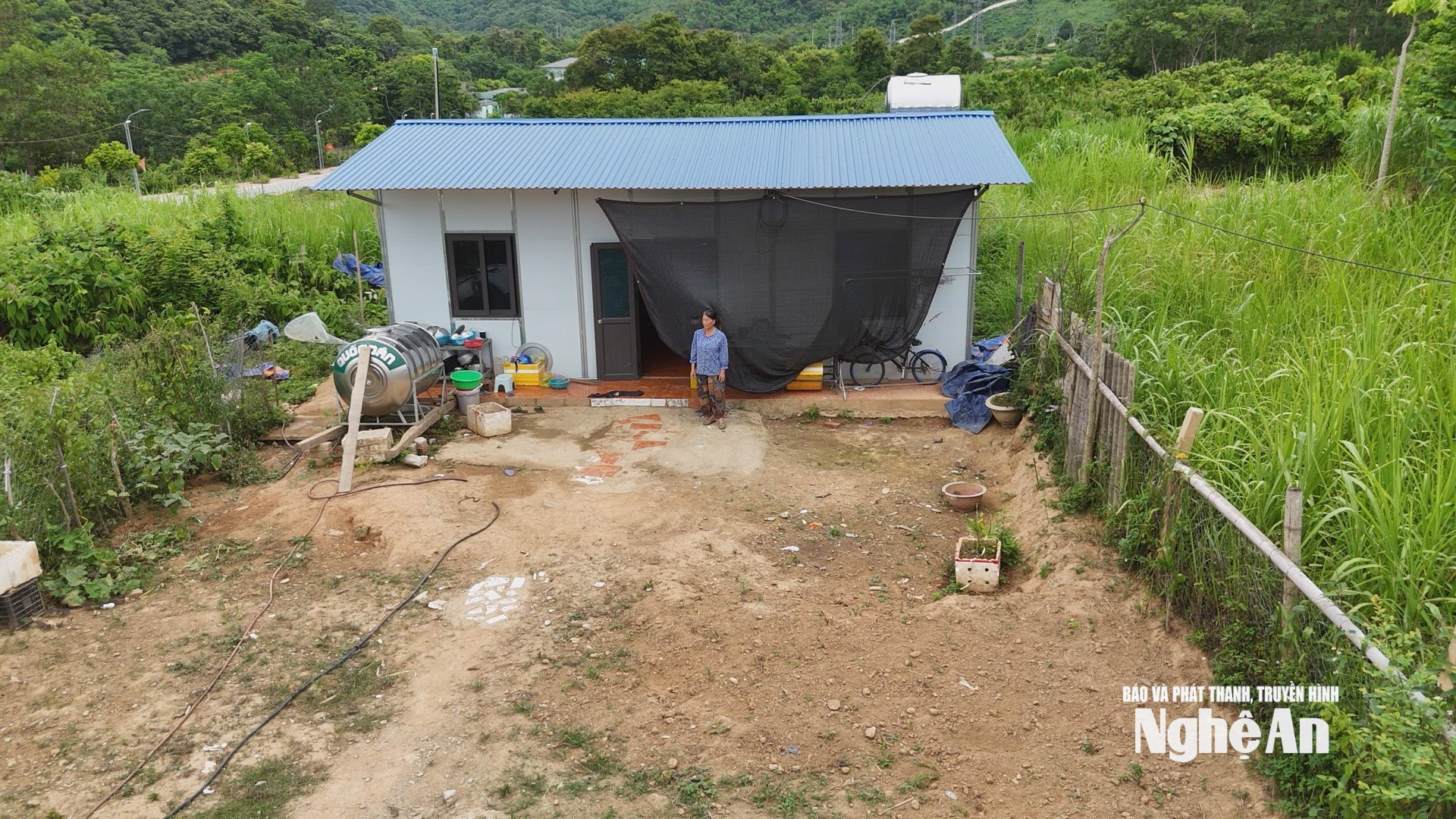Bà Quang Thị Phong trước ngôi nhà lắp ghép do Bộ Công An hỗ trợ tại Khu Tái định cư Vườn Xoài, xóm Hòa Nam, xã Tương Dương, Nghệ An. Ảnh Nguyễn Toàn