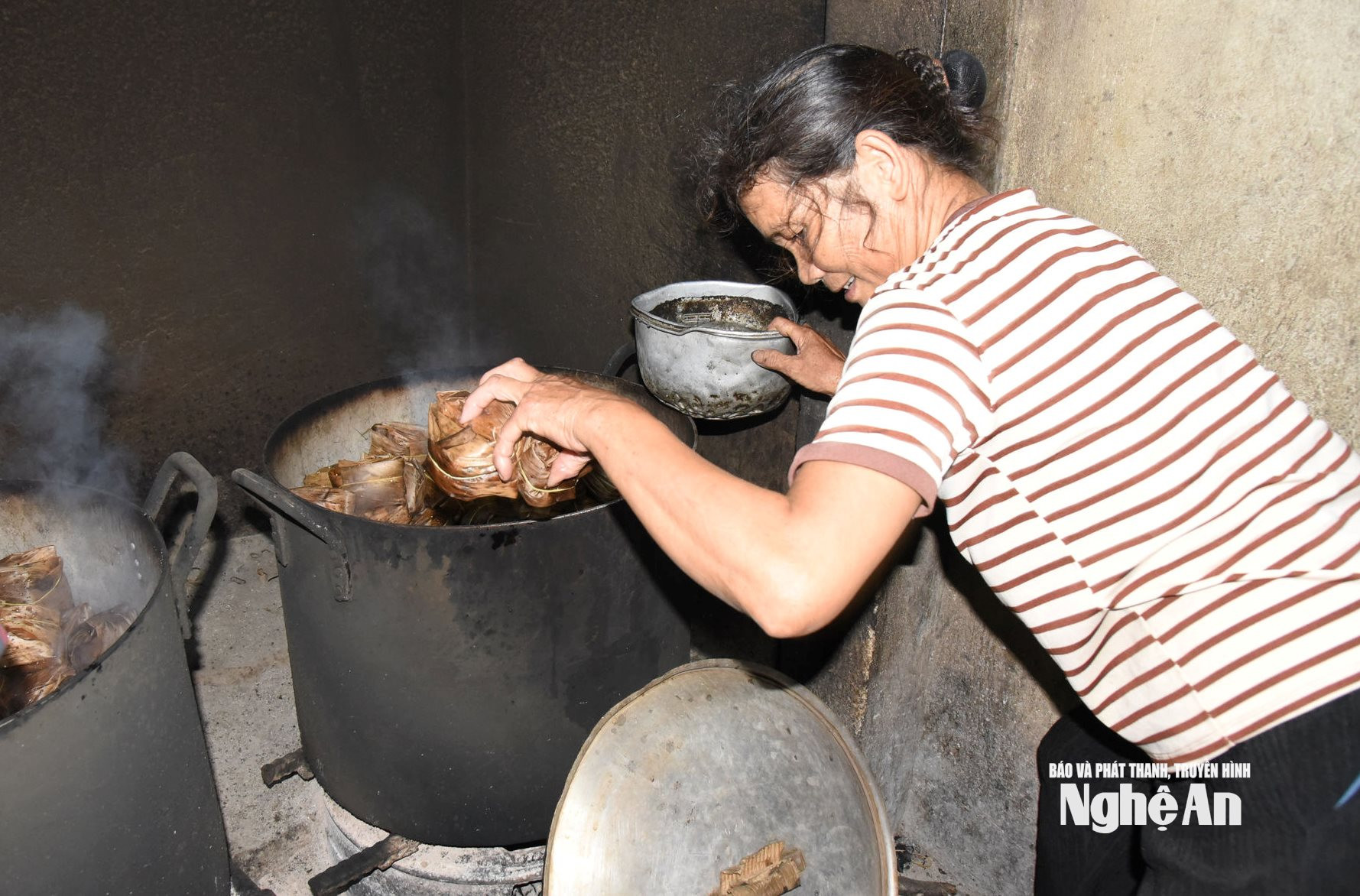 Mỗi mẻ bánh được hấp 1 tiếng rưỡi đồng hồ và khi vớt người thợ kèm theo 1 nồi nước lạnh để nhúng tay nhằm giảm sức nóng của bánh lên tay. Ảnh HT