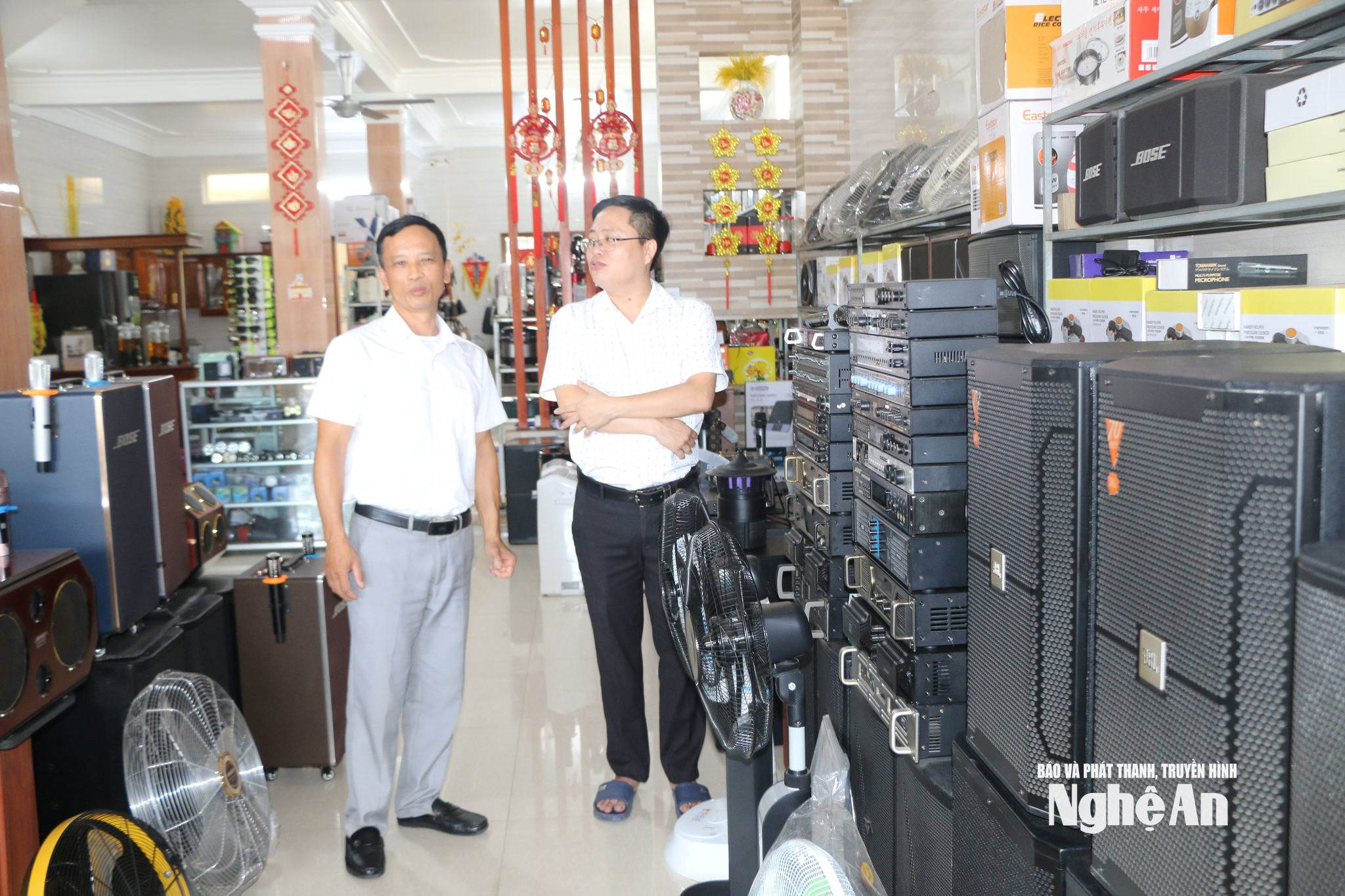 Ông Cao Văn Dương - Bí thư chi bộ Nghi Thủy 1 trao đổi với cán bộ Ban xây dựng đảng phường Cửa Lò về sự nêu gương của đảng viên trong phát triển du lịch. Ảnh KL